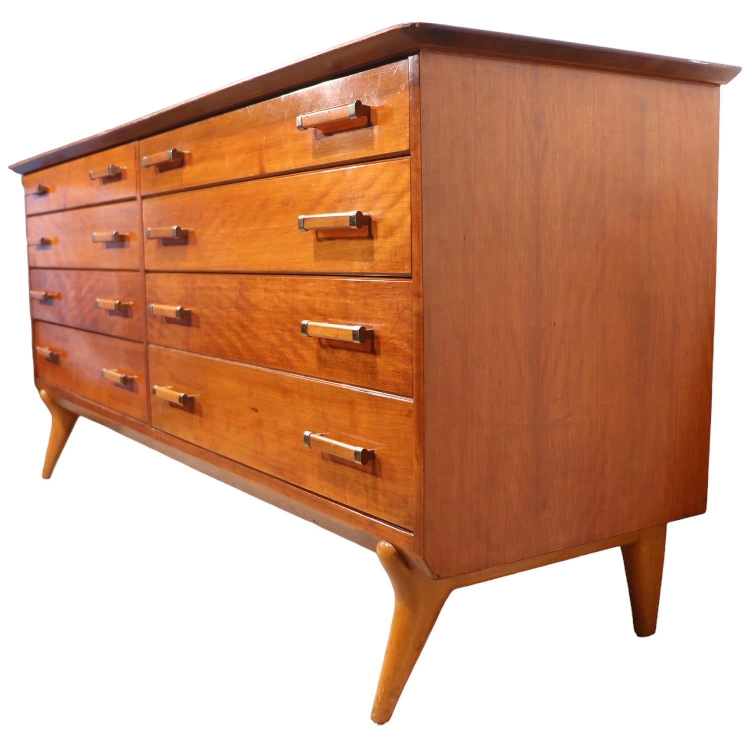 Excepcional mediados de siglo  Cómoda doble de siete cajones, diseñada por Renzo Rutili para Johnson Furniture Company hacia la década de 1960. La cómoda cuenta con dos bancos de  cajones, un tablero arquitectónico biselado en voladizo y patas