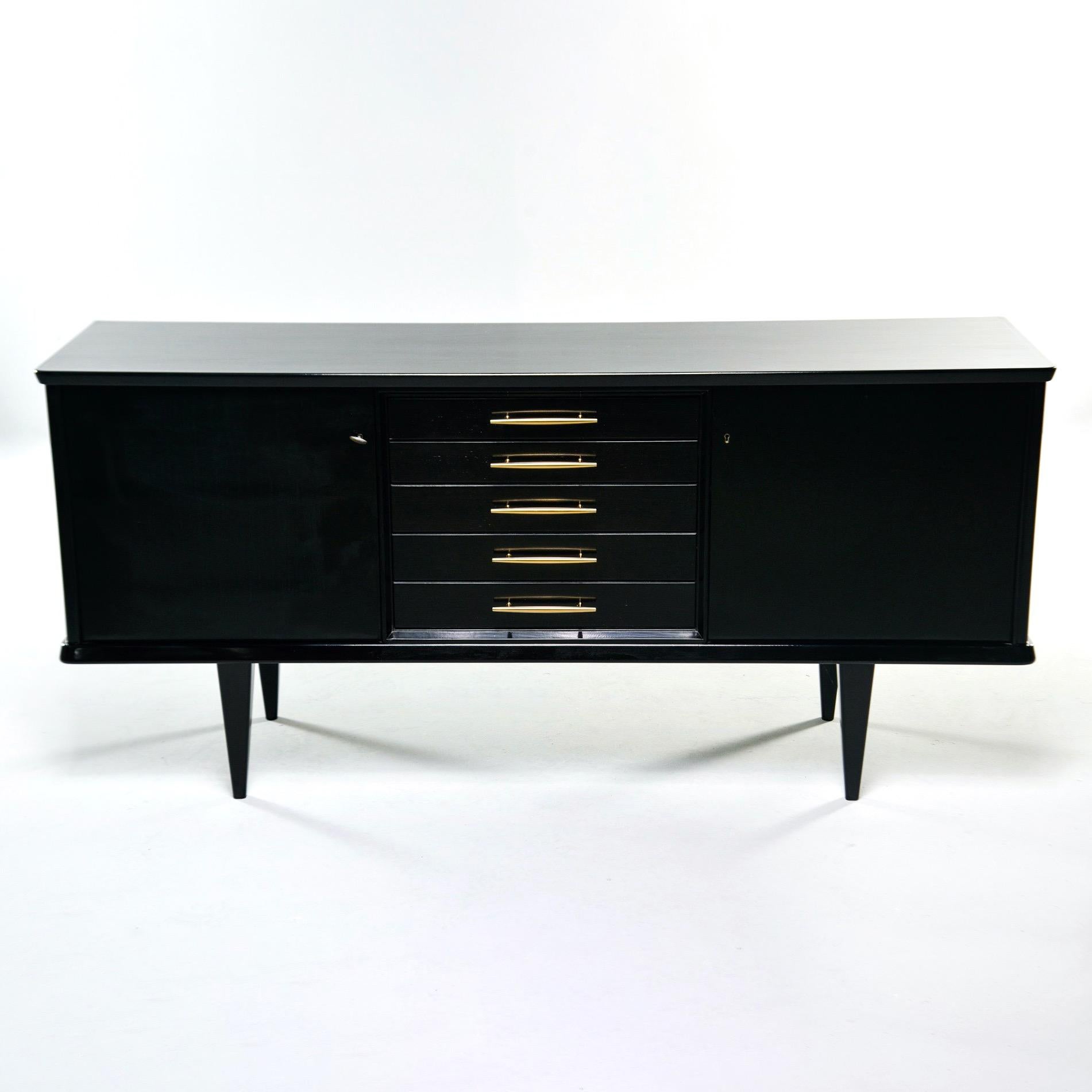 Found in England, this circa 1960s mahogany credenza has a new, professionally applied ebonized finish. Middle section features five functional drawers with new, streamlined brass hardware. Top two drawers are felt lined. Side compartments have