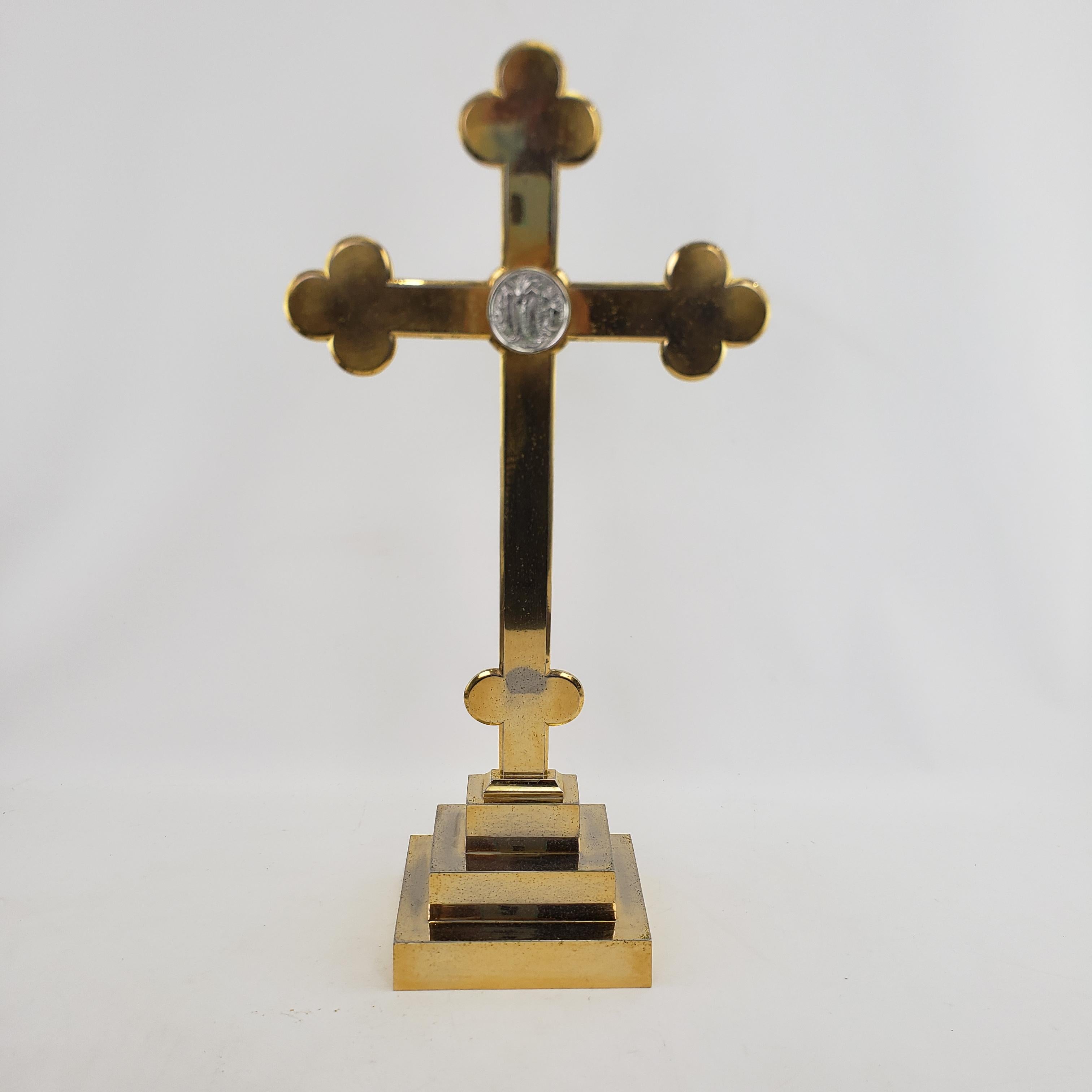 This large brass plated cross is unsigned, but presumed to have originated from Italy and dating to approximately 1970 and done in the period Mid-Century style. The cross is composed of a brass plated steel with a stepped base. Please note this is a