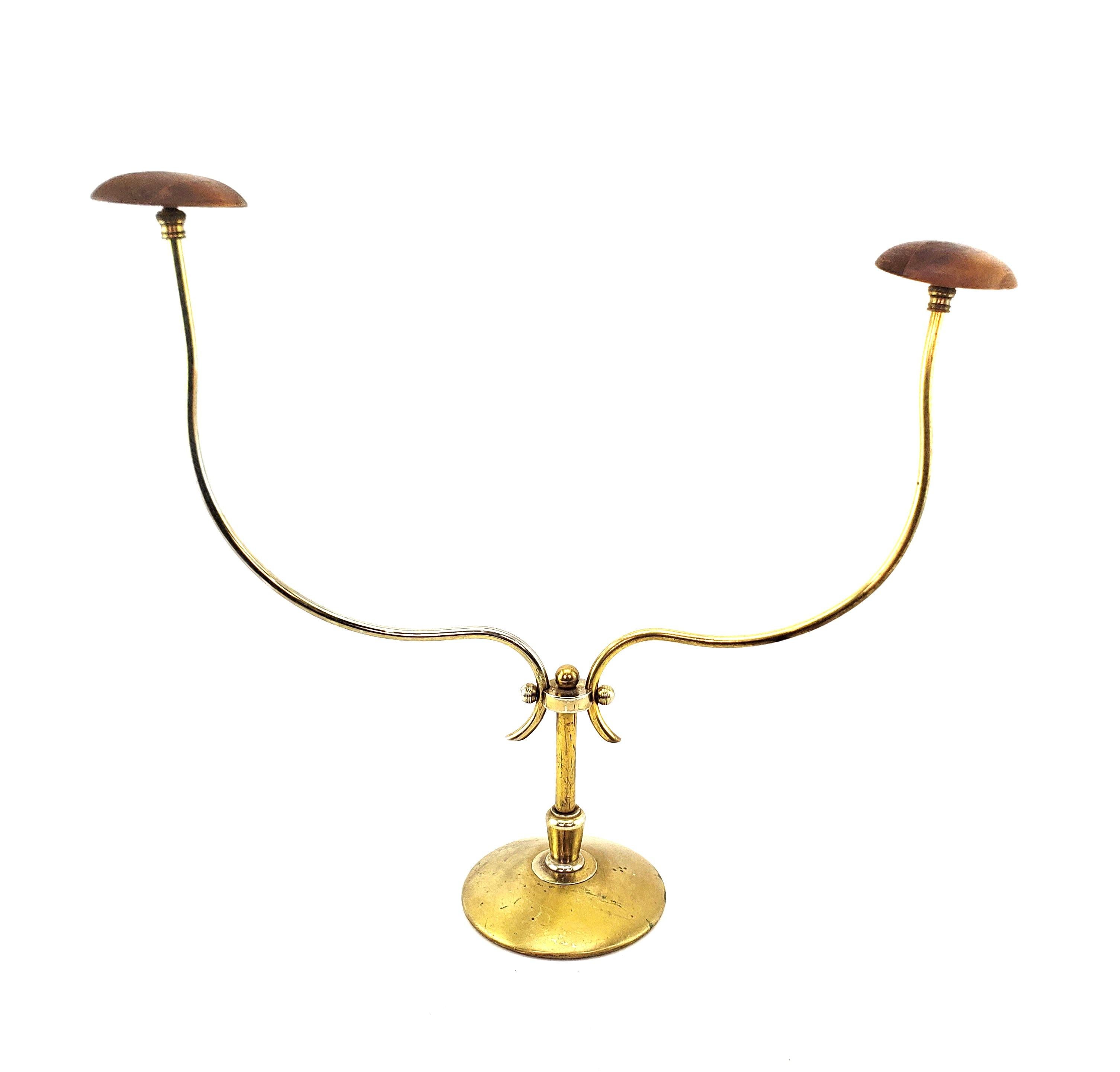 This hat stand is unsigned by the maker, but presumed to have originated from the United States and date to approximately 1960 and done in the period Mid century Modern style. The stand is composed of metal tubing with a gold toned finish with two