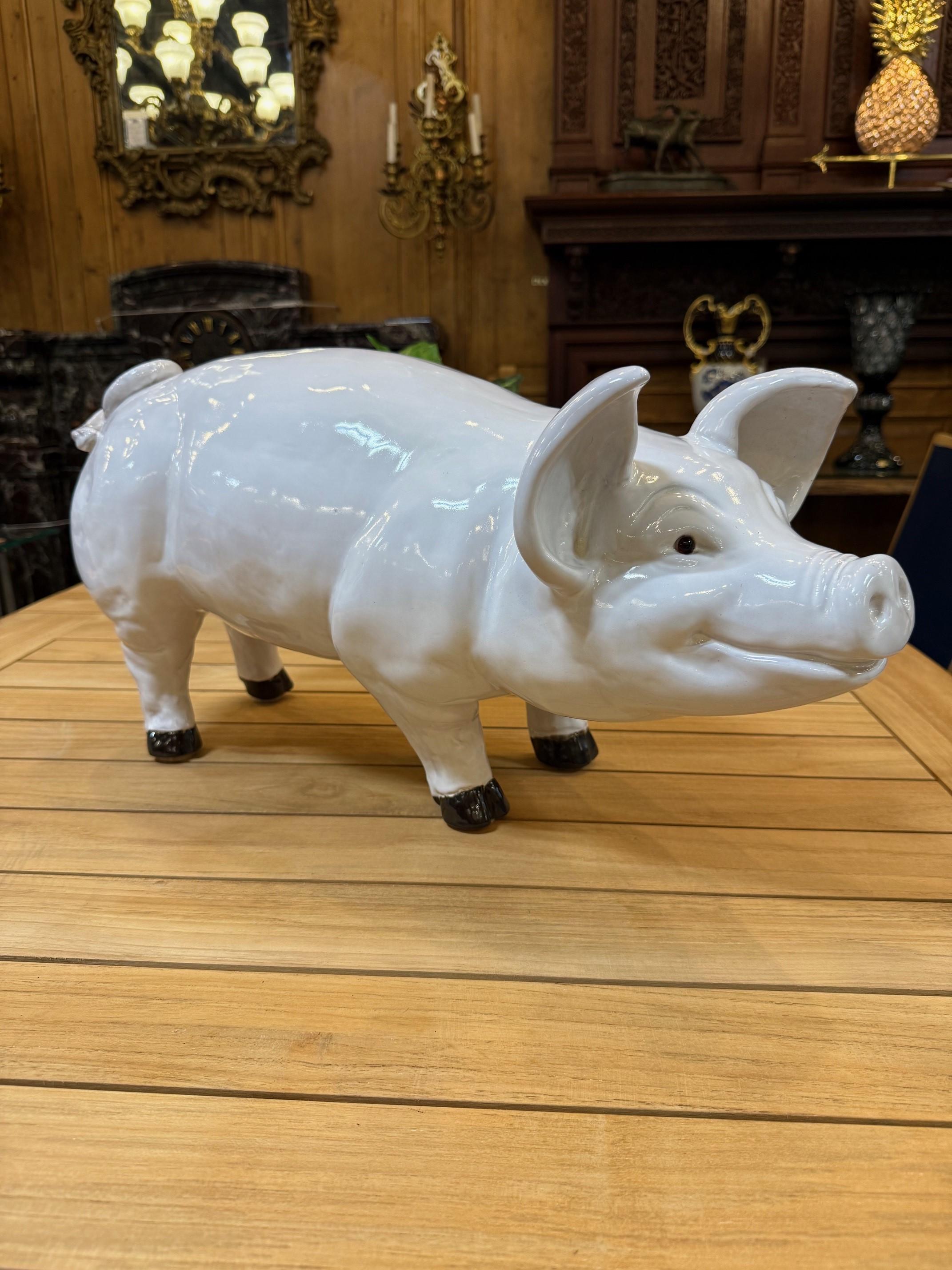 A large-sized Mid-century white glazed ceramic figure representing a naturalistic pig. Finely detailed with glass eyes. France, circa 1940s. This is a great looking pig with a nice friendly smile. It's in very good condition, shown in the photos and