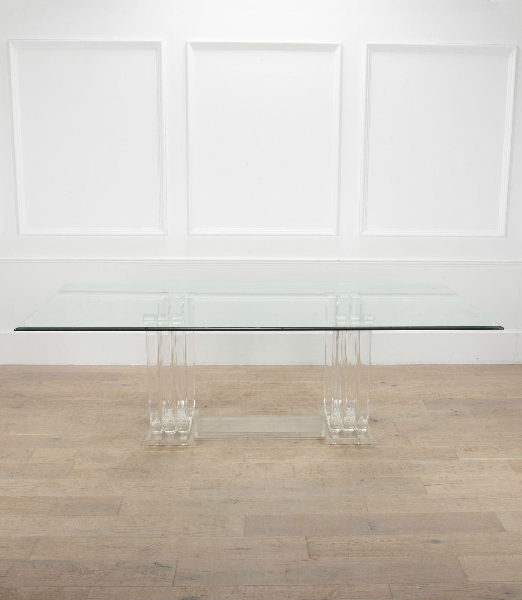 Grande table de salle à manger élégante du milieu du siècle.
Plateau en verre reposant sur deux pieds en plexiglas en forme de tulipe.