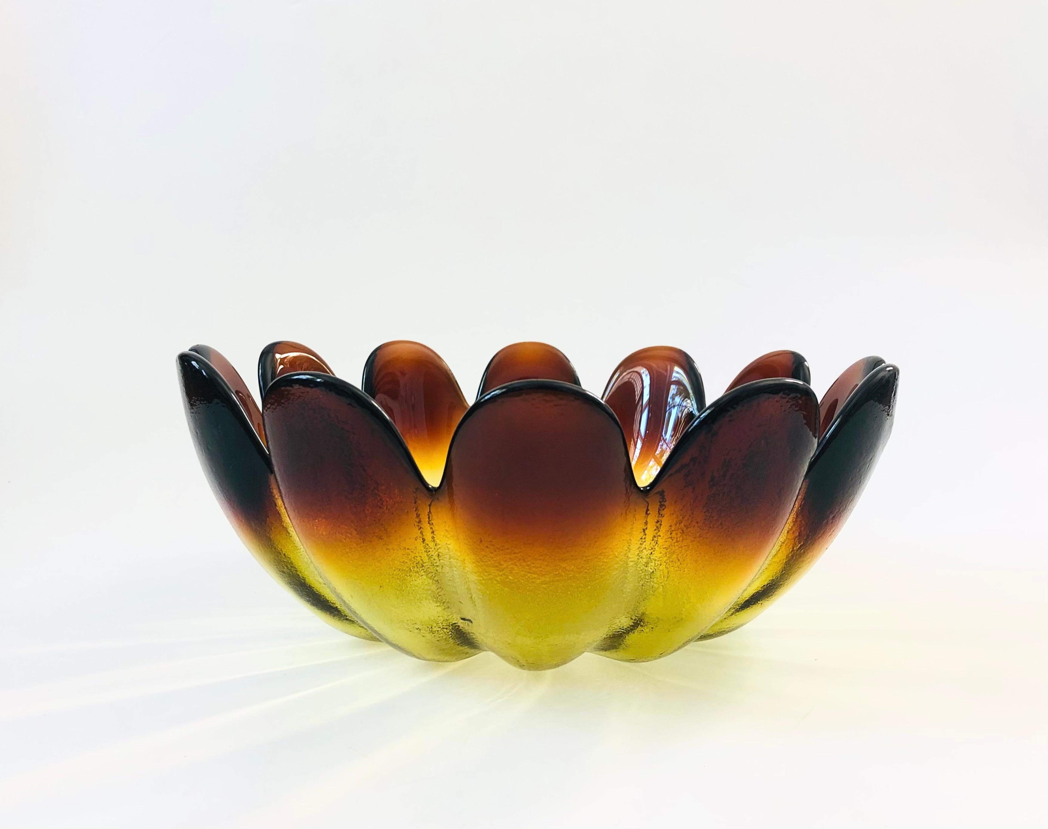 A large mid century glass lotus shaped bowl by Indiana Glass. Beautiful color to the glass which fades from dark brown at the edges of the petals to yellow towards the base. Slightly textured exterior and smooth interior. Made of thick heavy glass.