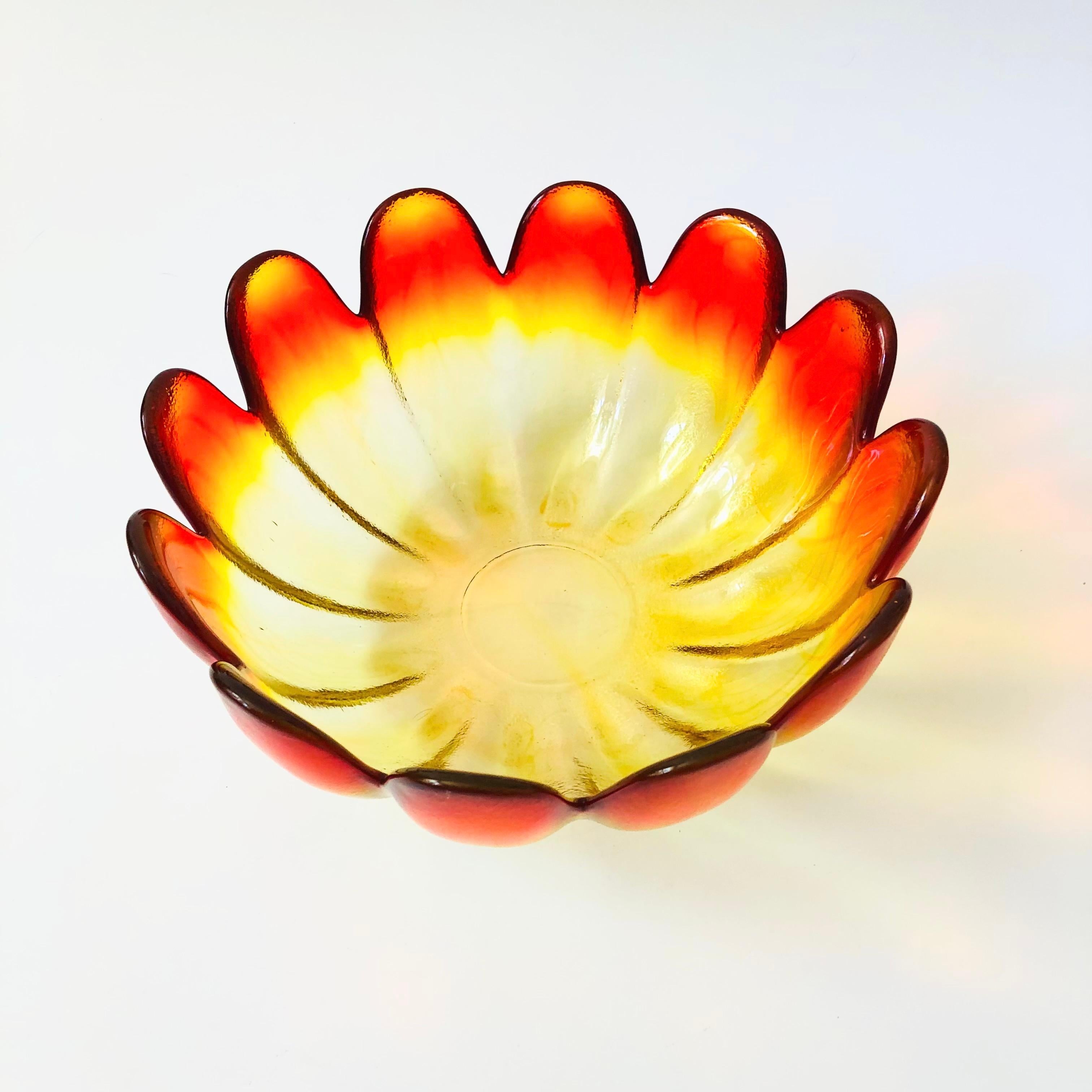 A large mid century glass lotus shaped bowl by Indiana Glass. Beautiful color to the glass which fades from orange at the edges of the petals to yellow towards the base. Slightly textured exterior and smooth interior. Made of thick heavy glass. A