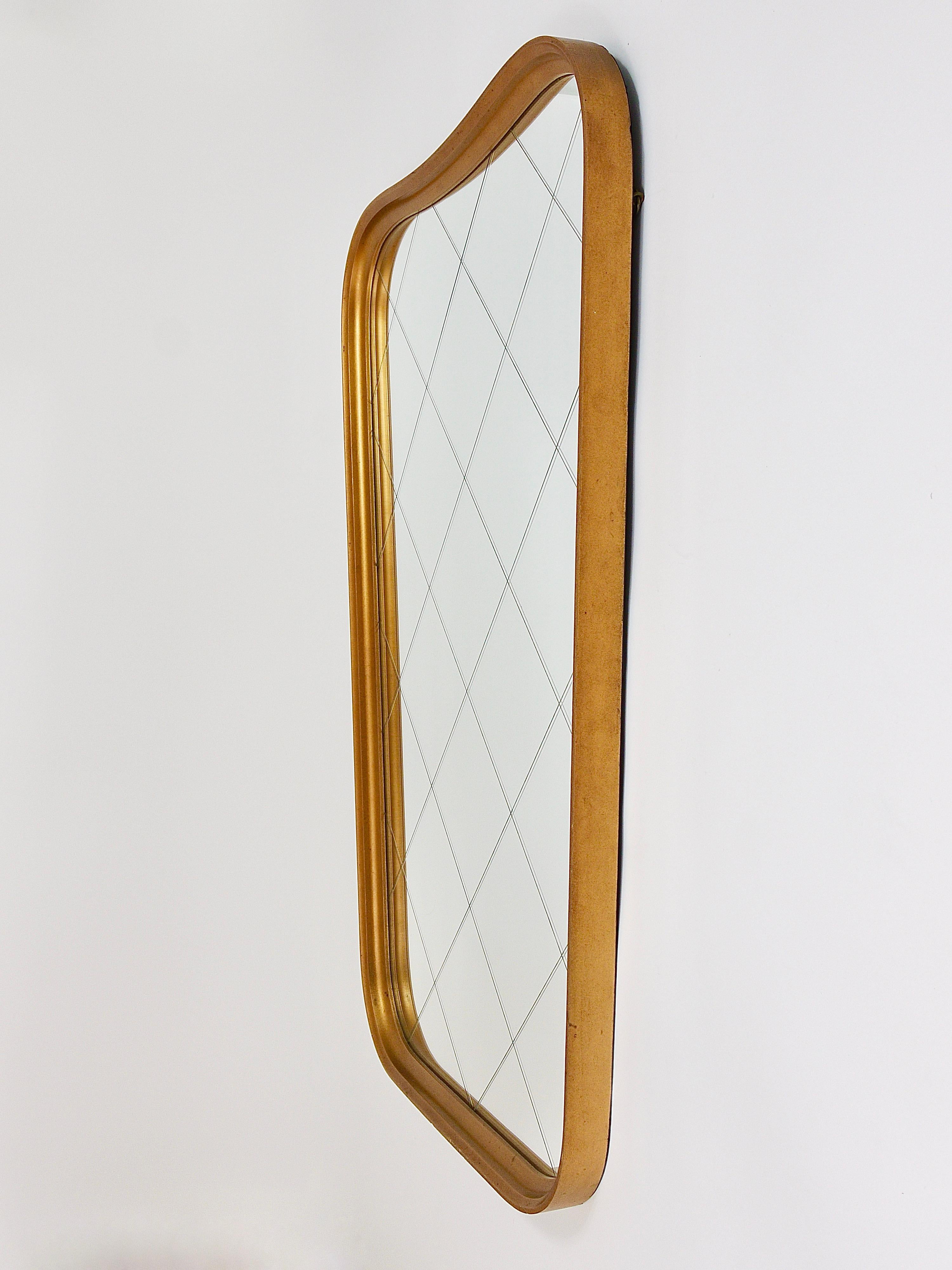 A charming Austrian modernist wall mirror with a golden bent wood frame and a nice checked decor pattern on the mirror glass. From the 1950s. This beautiful mirror has a lovely classical shape and is in very good condition with marginal patina on