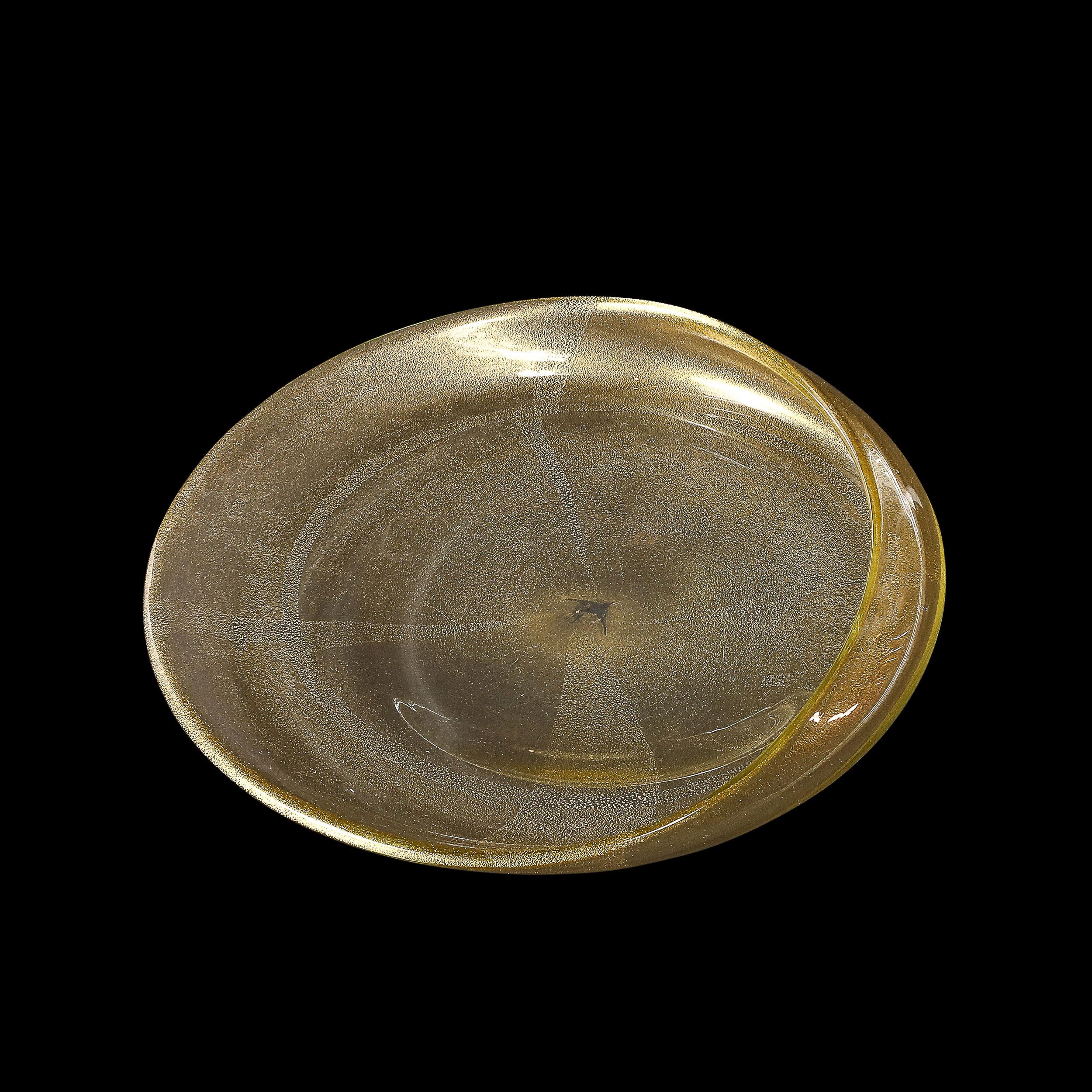 This magnificent mid-century modernist hand-blown Murano glass bowl is a testament to the unparalleled artistry and innovation of Italian glassmaking. Crafted with meticulous skill, it features embedded 24-karat gold fleck detailing, which adds a