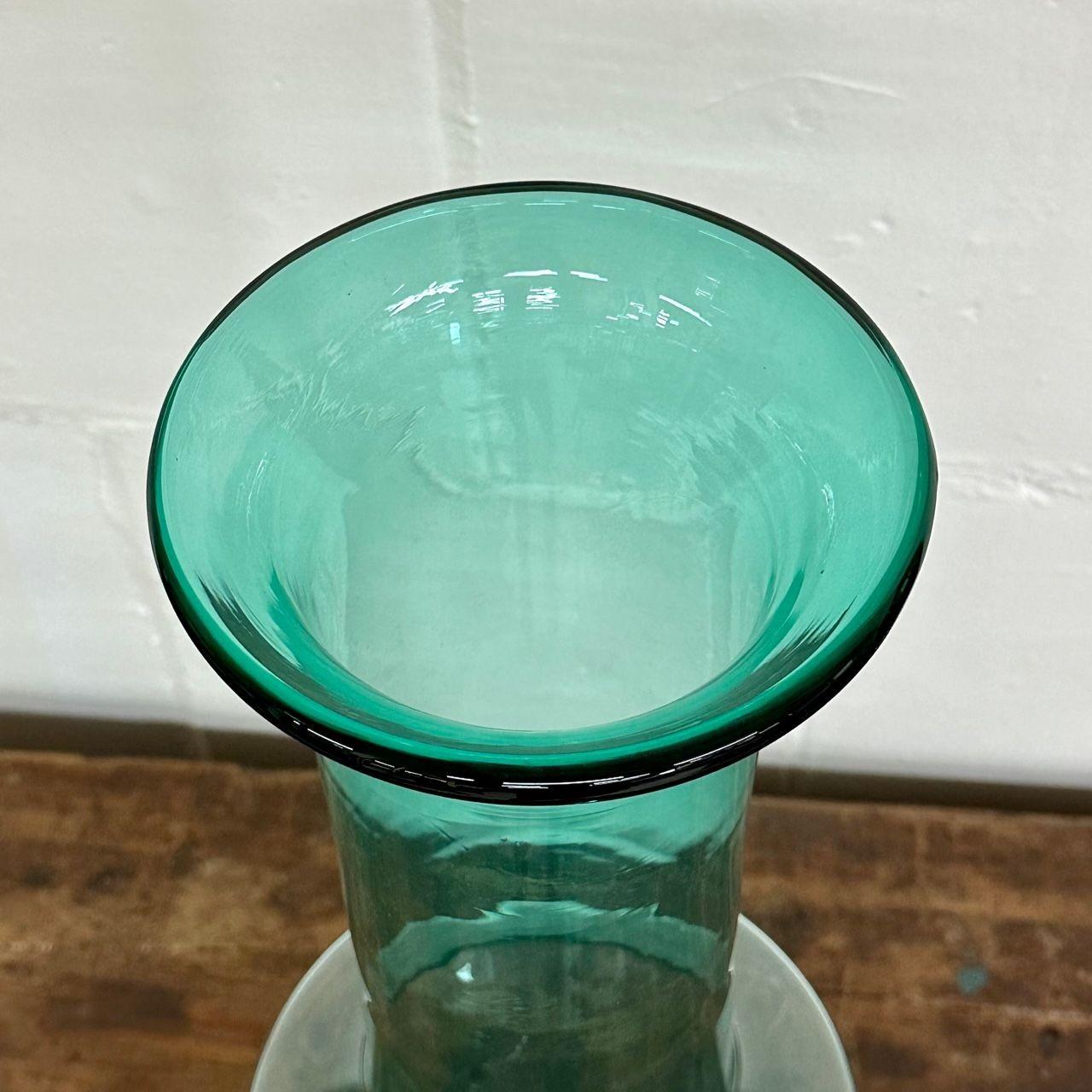Large midcentury hand blown glass turquoise long floor or table vase by Blenko
 
Teal floor or table vase deigned by Wayne Husted for Blenko.
 
Blown Glass
United States, 1960s
 
Opening is 6.25