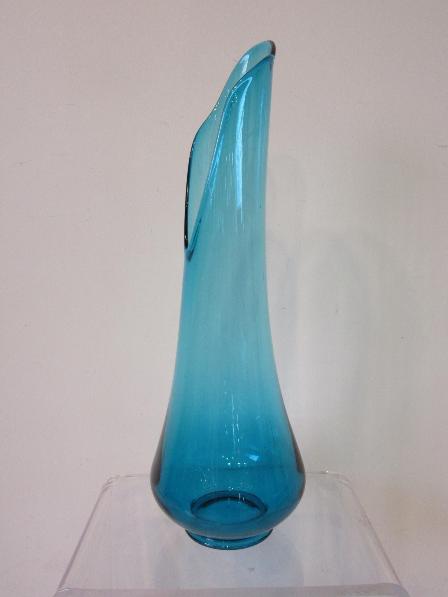 A very large hand blown aqua blue glass vase with sculptural wide mouth opening and curving sides forming into the bulbous base. A great piece of midcentury era large glass shapes in peacock blue for LE Smith from their Simplicity Line .