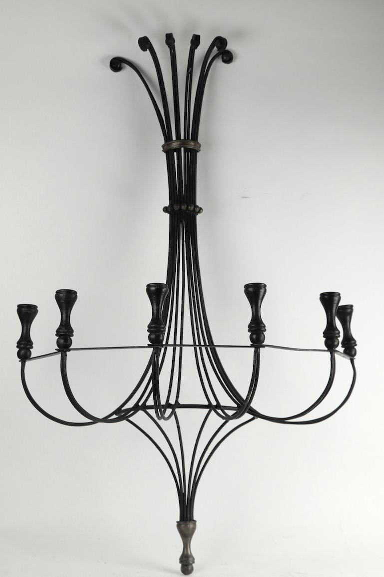 Large 6-light candle sconce of wrought iron, brass, and wood. The sconce has a wrought iron structure, with turned wood candle cups, and cast brass trim. It is large scale making it a very impressive visual statement when hung. Probably American