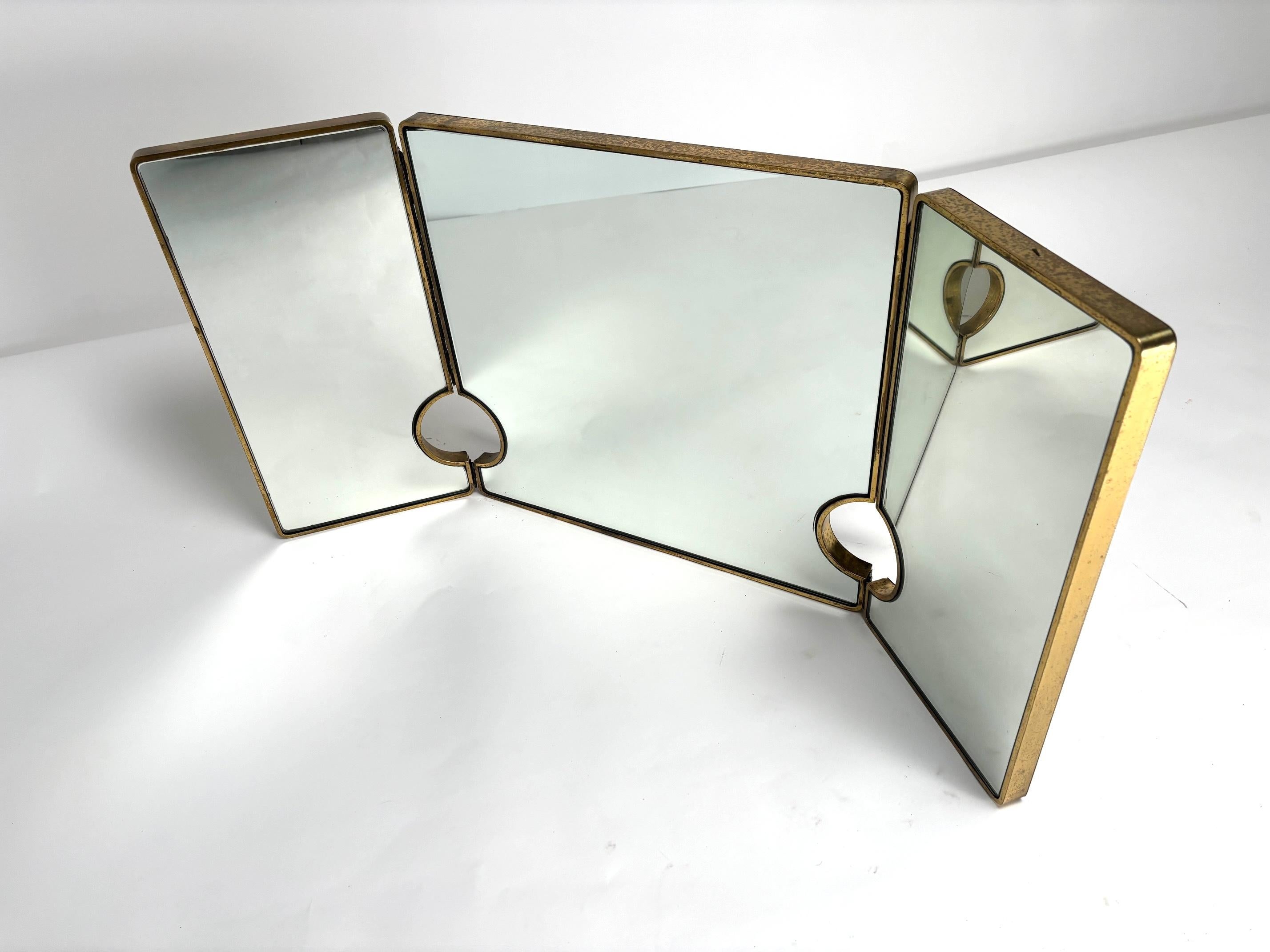 Grand miroir triple en laiton italien du milieu du siècle, années 1950

Ce miroir très original se distingue par son élégance exquise. Le cadre en laiton, avec sa chaude tonalité dorée, reflète le savoir-faire artisanal de l'époque, tandis que le