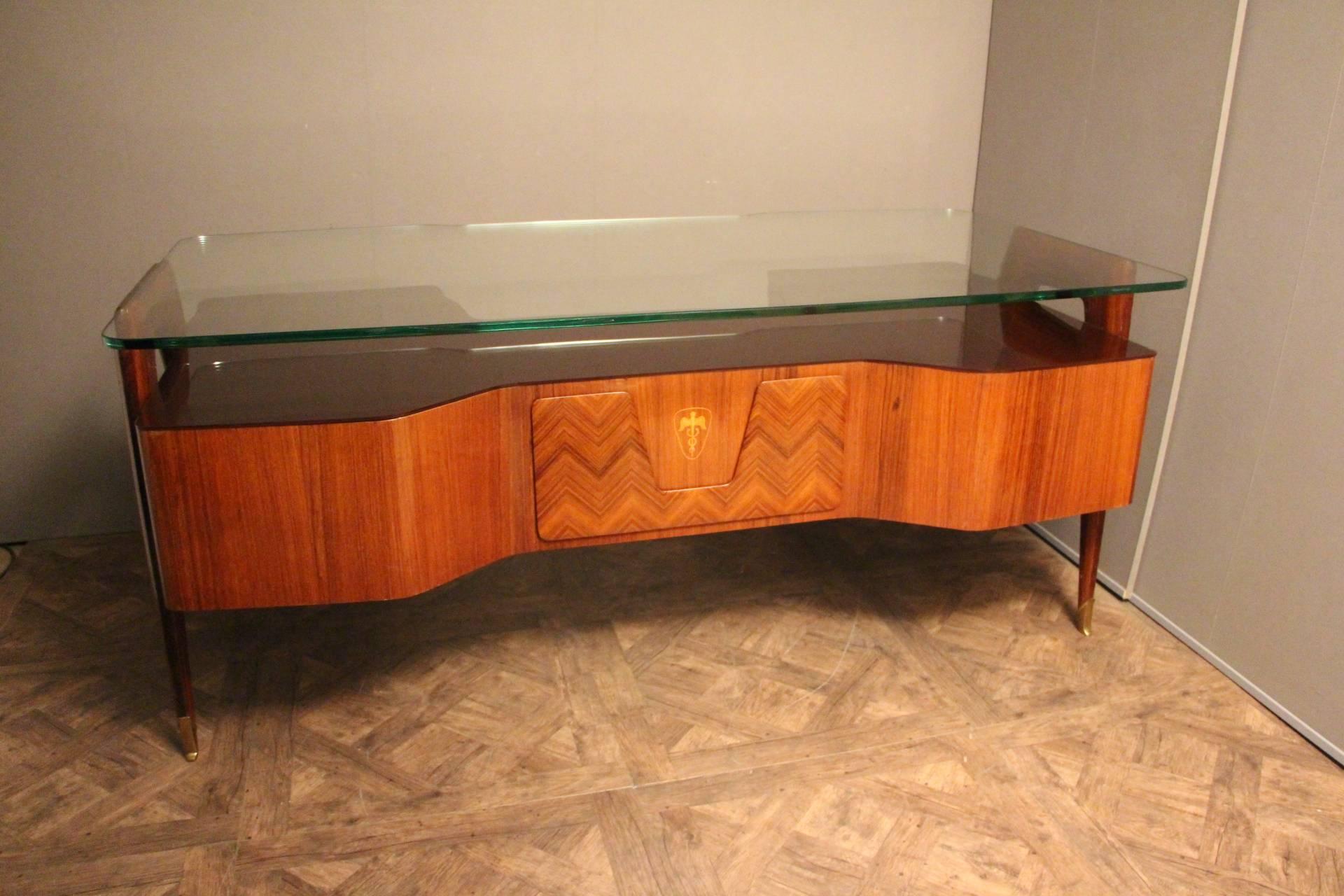 This impressive executive desk by the 1950s Italian designer, Vittorio Dassi, features a very comfortable 1.5 cm thick floating glass top, underneath, there is another very thick piece of black glass then two columns of two sturdy drawers. Solid