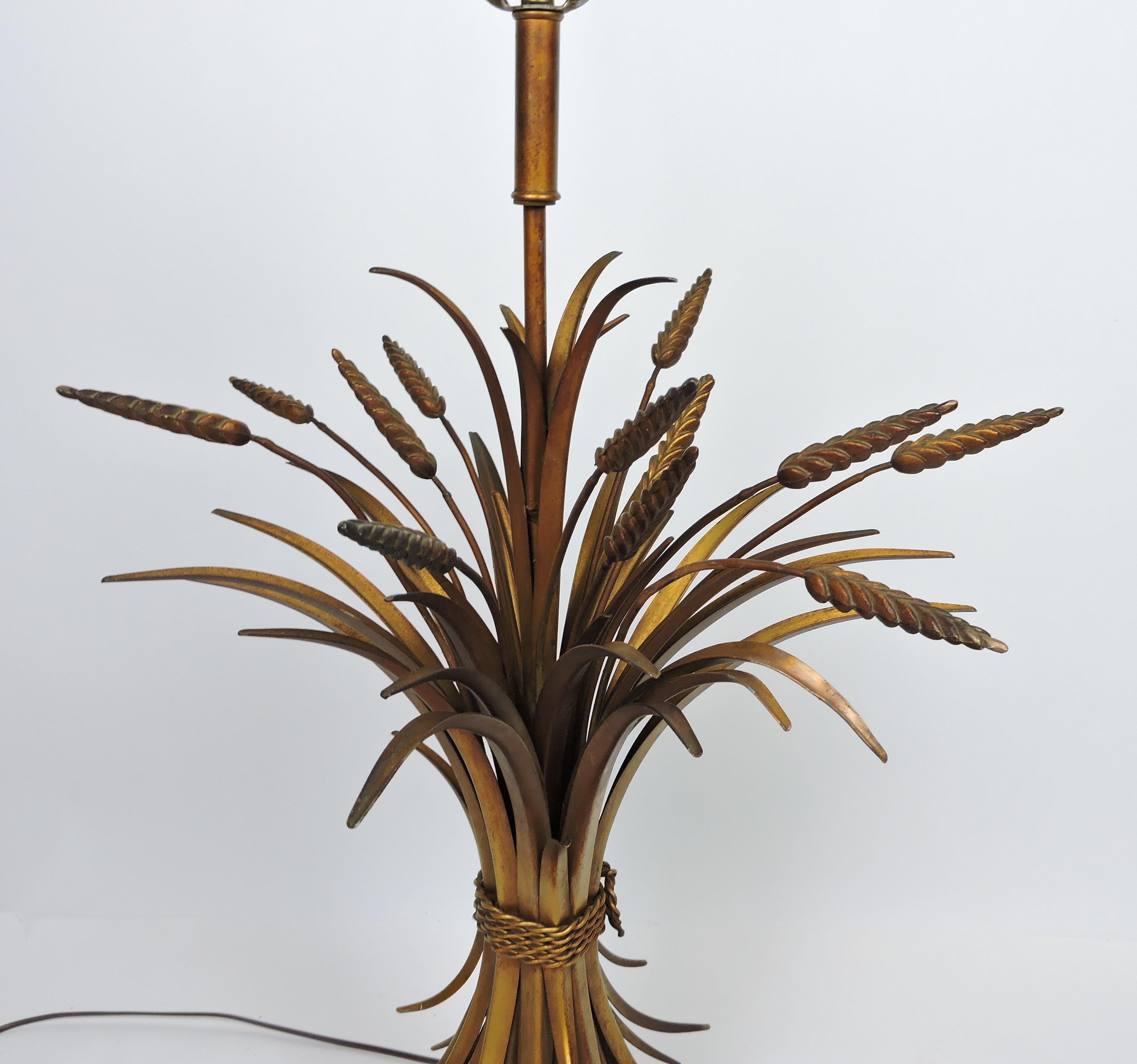 Beautiful large Italian sheaf of wheat gilt metal table lamp. This lamp is an impressive 43.5 inches high to the top of the finial and has a nice, full look, and sits on a circular black and gold wooden base. It has all new wiring and takes a 3-way
