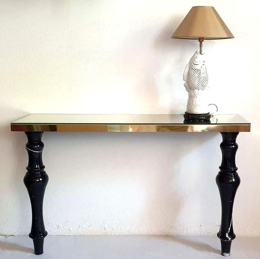 Large Mid-Century Modern console table, Italy, Carrara area in Italy, circa 1980s.
The vintage console table is made of two black sculpted marble legs and a brass rectangular top, covered up with a transparent glass.
The Neoclassical console has a