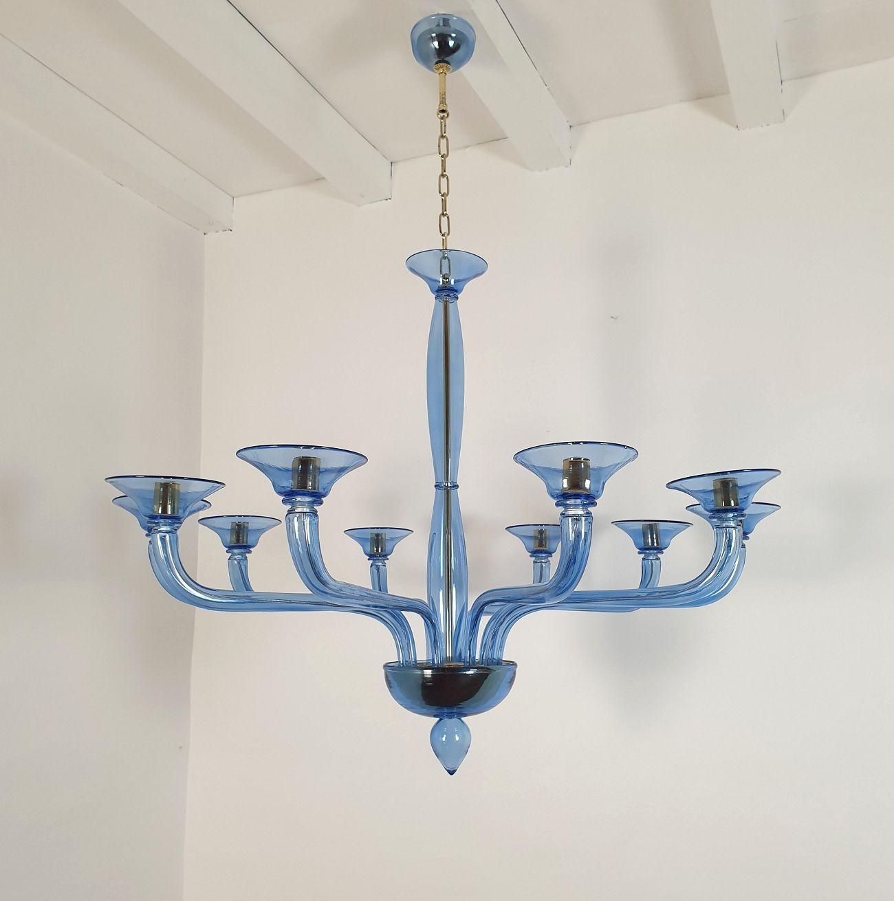 Mid-Century Modern blue Murano glass chandelier, attributed to Seguso, Italy 1980s
The large chandelier is made of transparent blue handmade Murano glass with gold plated mounts.
The Murano chandelier has 10 arms/lights.
It's rewired for the US (or
