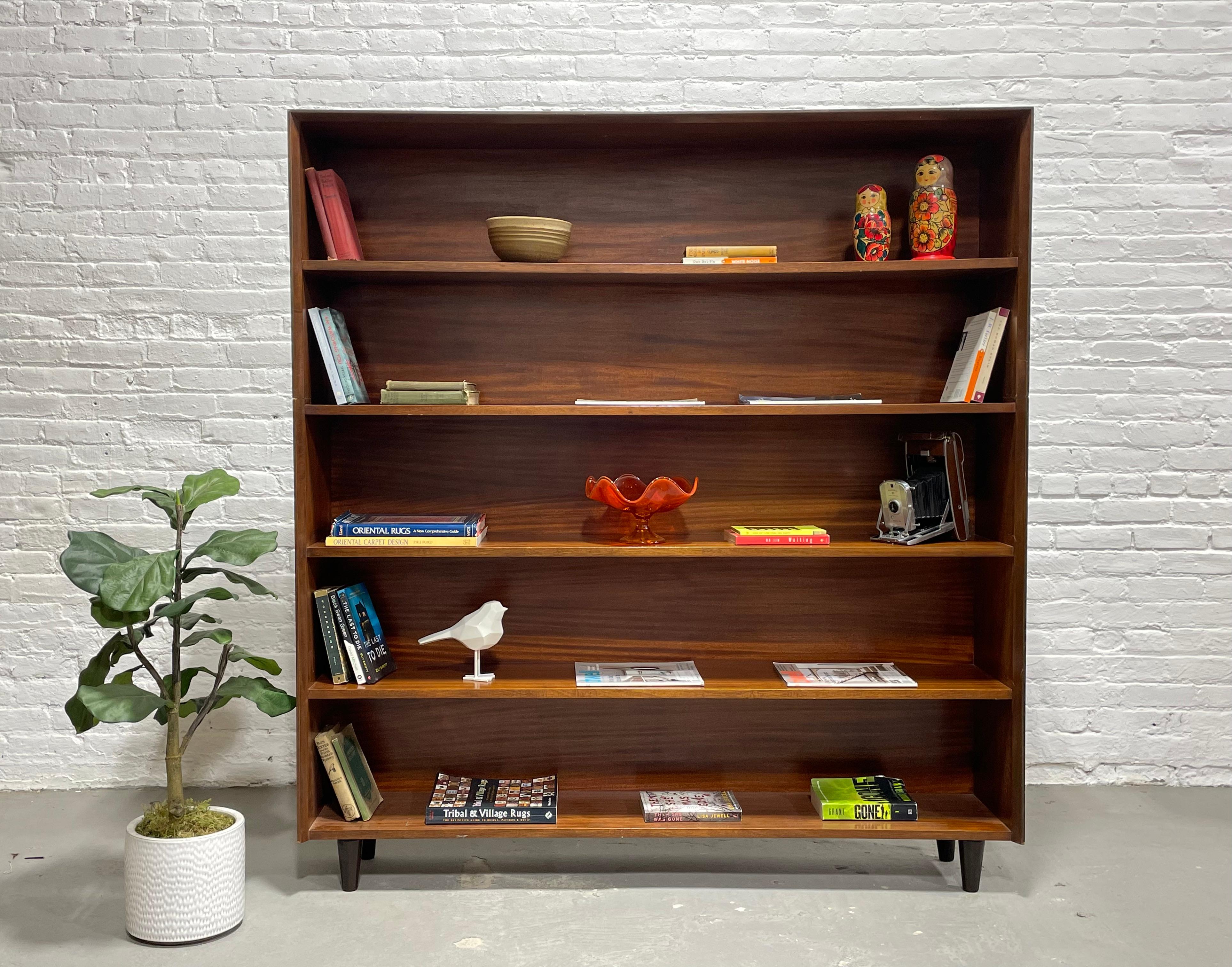 Large Mid-Century Modern Bookcase by Jens Risom, circa 1960s. Loads of storage for all your books or showcase your collectables across the five long and wide shelves. Composed of two parts and sits on thick and solid tapered wood legs. The wood