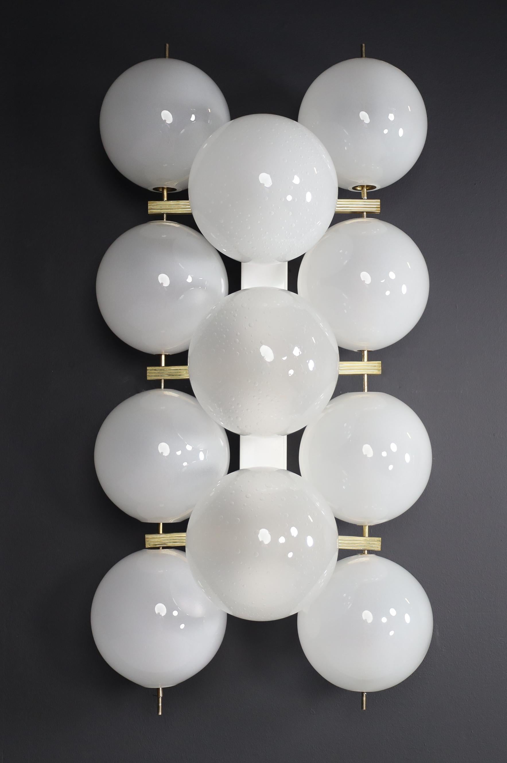Large Mid-Century Modern brass and frosted glass wall chandeliers with rectangular fixture and hand blowed frosted glass globes. The bulbs are connected directly to a fixture that is connected directly to the wall or ceiling. The pleasant light it