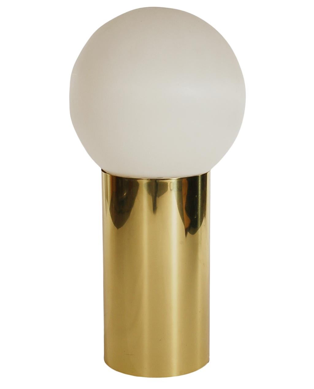 A simple yet sophisticated design floor lamp from the 1970s. It features a brass-clad cylindrical base with a molded plastic sphere shade. Takes one standard bulb. Tested and working.