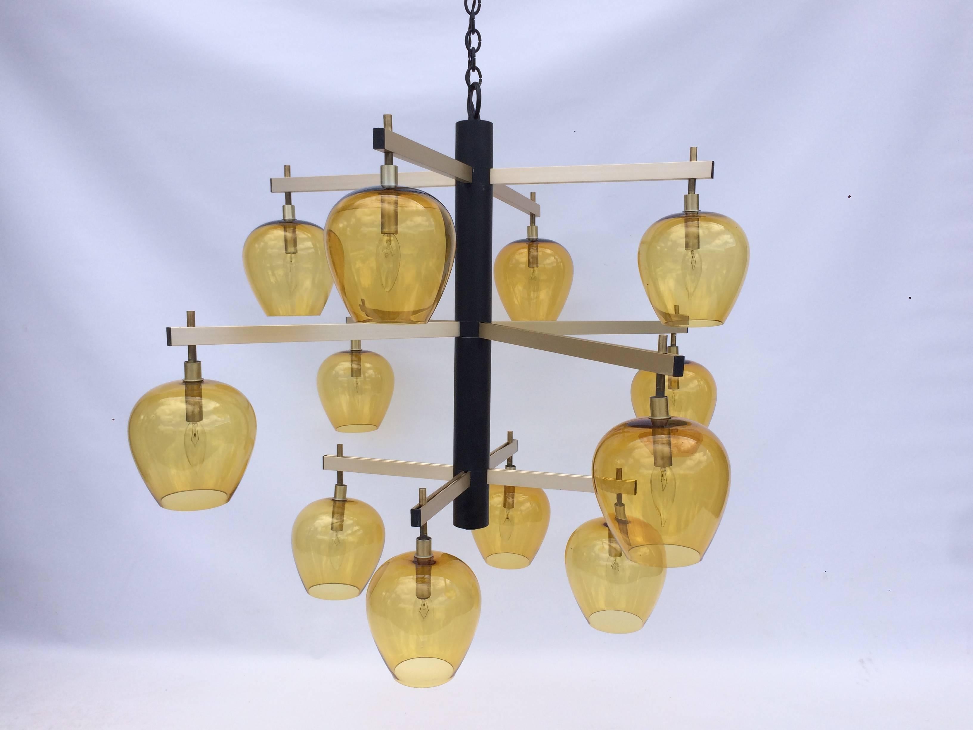 Chandelier has 12 arms which hold 12 amber glass shades. Chandelier comes a black chain and canopy. Chandelier has candelabra sockets.