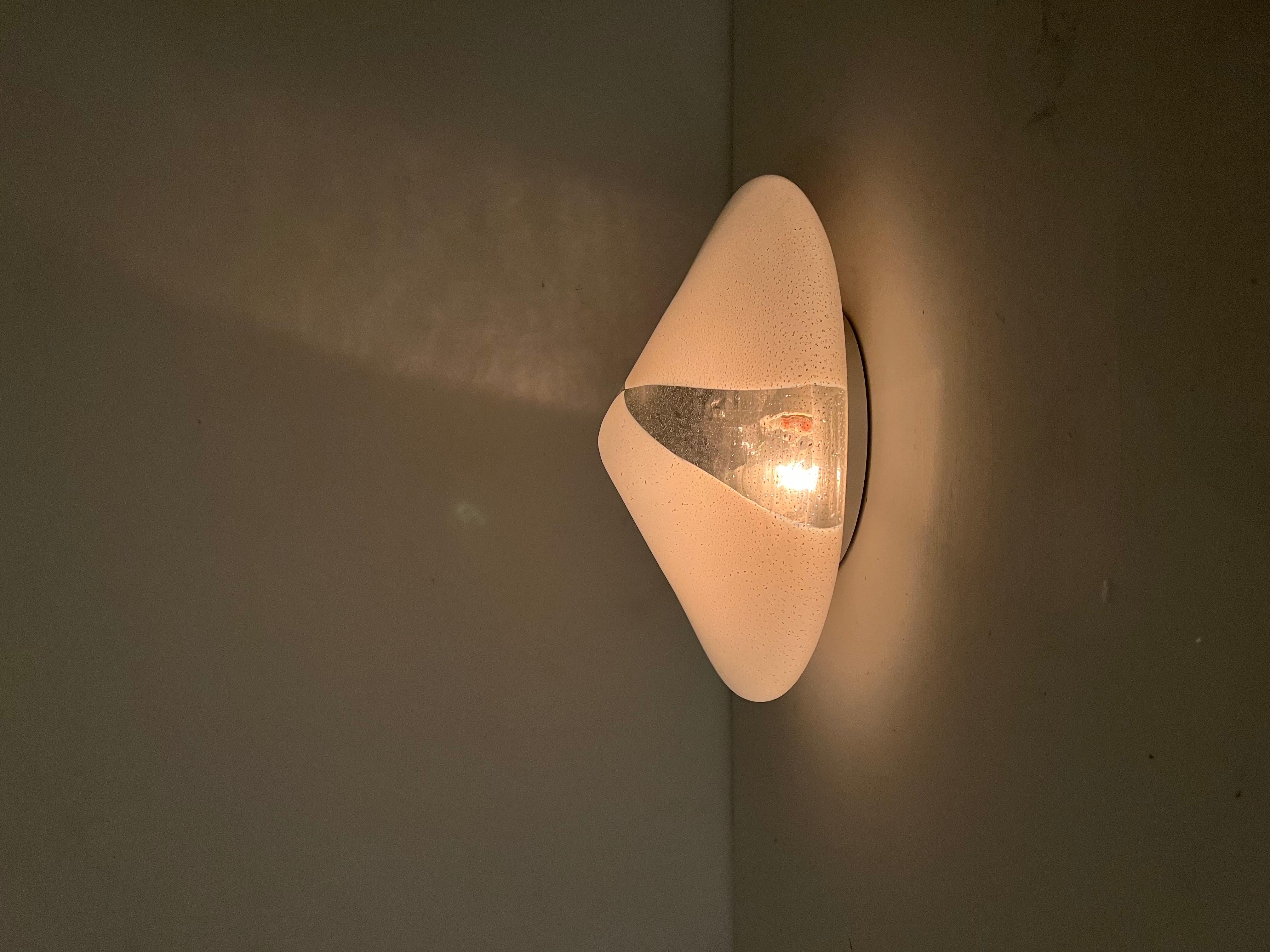Mid-Century Modern flush mount or sconce made in Murano Italy circa 1970 and produced in white and clear 'Pulegoso' glass . This lamp s very much in the manner of what Mazzega was producing under Carlo Nason's direction in the 1970´s.
It holds 2