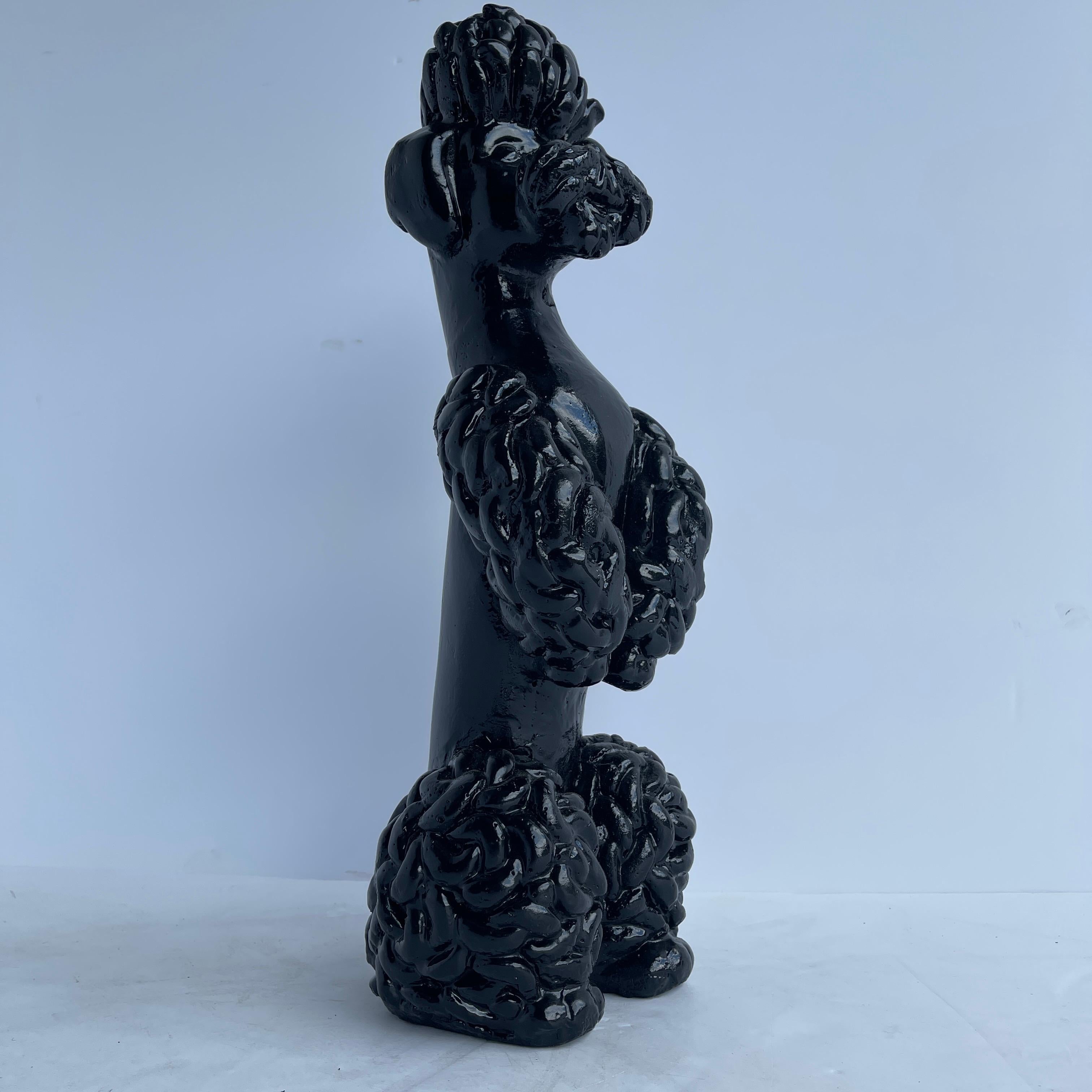 Mid-Century Modern large black poodle statue. This tall concrete rendering of a poodle boasts excellent detailing in his eyes and hair. It has been freshly painted in powder coated gloss black. The poodle handsomely stands on hind legs. Always on