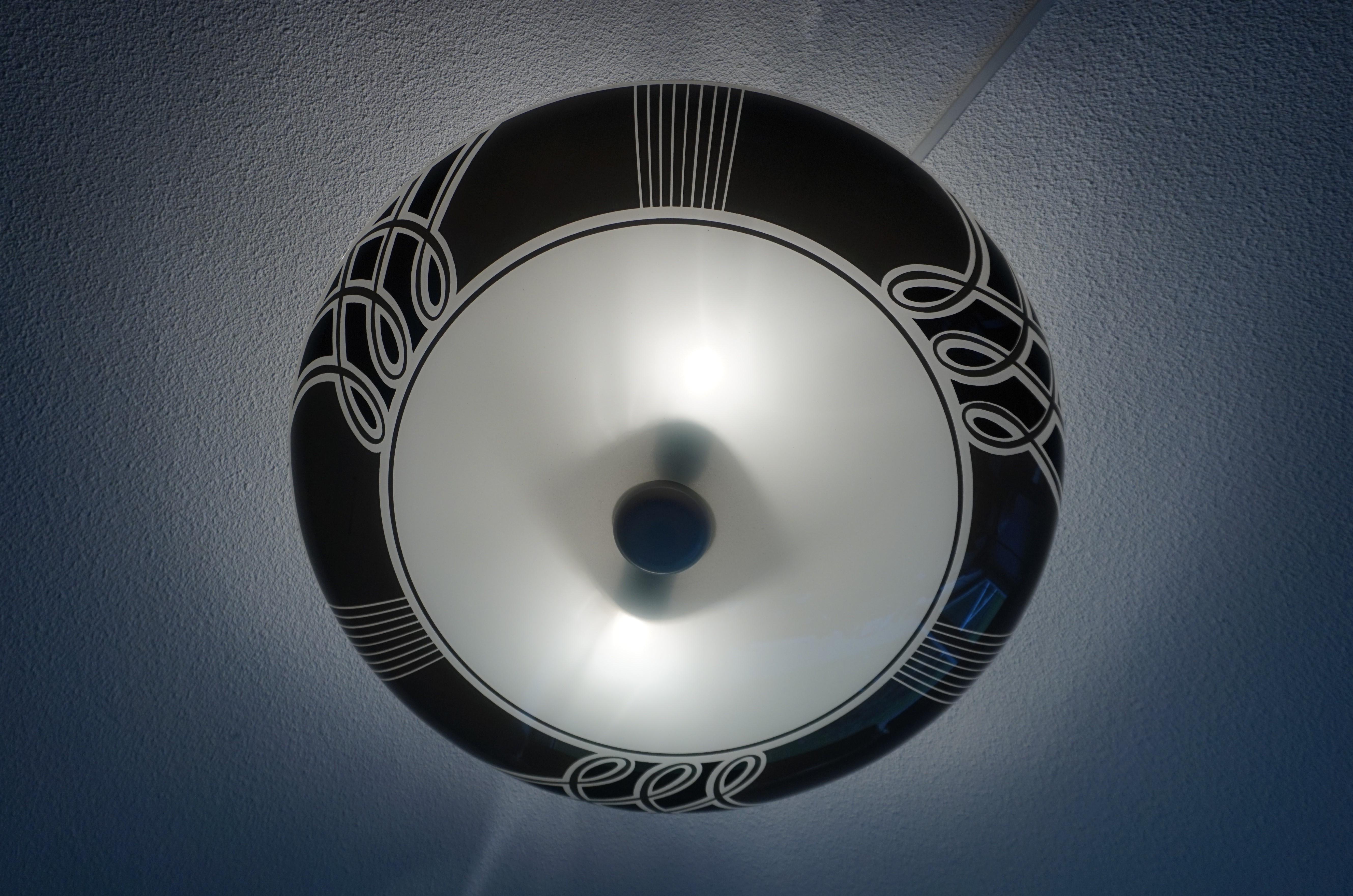 Rare and great looking, two-light midcentury flush mount.

This very stylish and large size midcentury light fixture with the unique black and white design is another one of our recent great finds. Both with the light switched on and off this fine