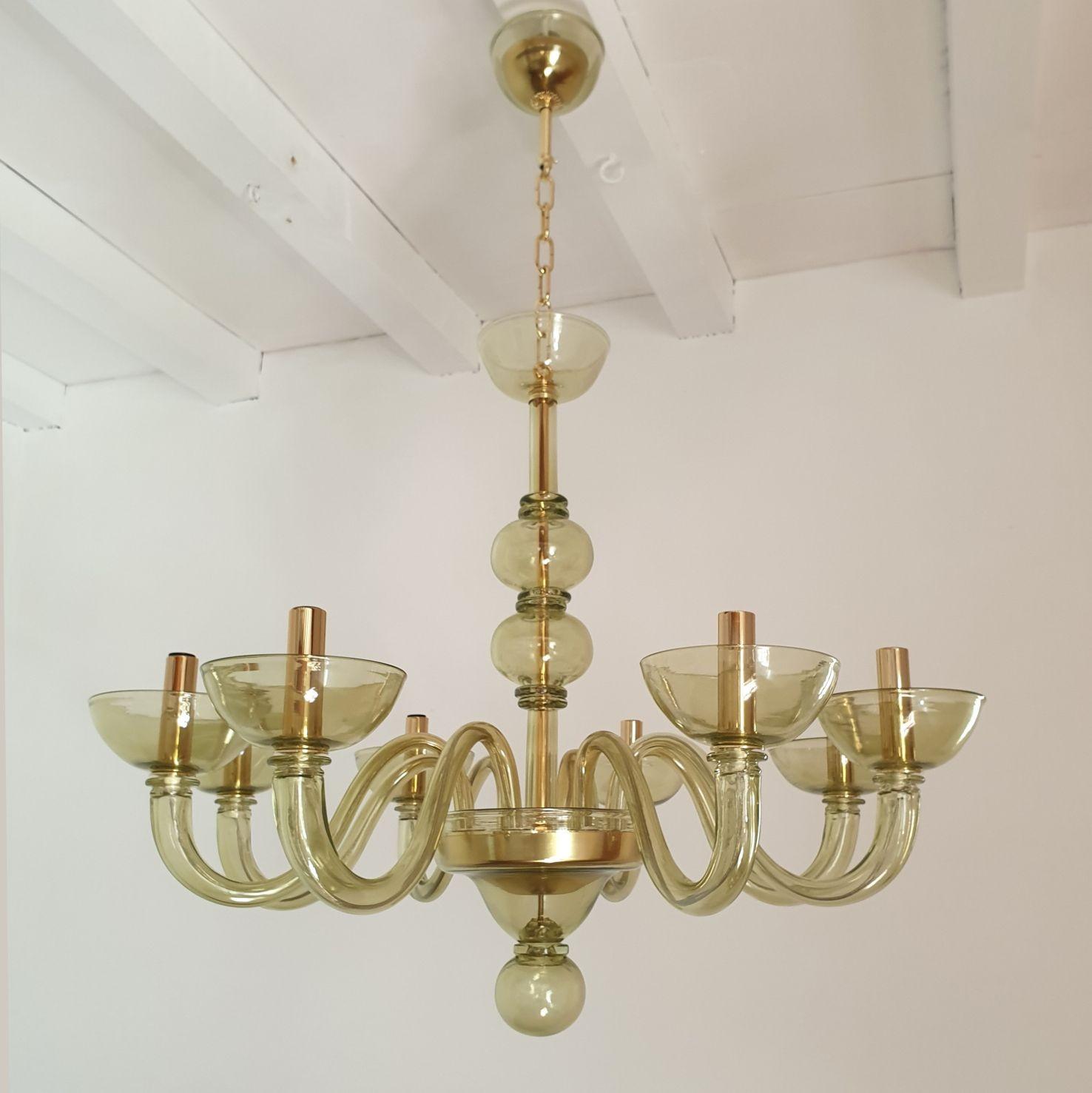 Mid-Century Modern light green Murano glass chandelier, attributed to Seguso - Italy 1980s 
The Murano glass chandelier is hand blown, in a light olive green color with gold plated mounts.
The neoclassical chandelier has 8 lights or arms.
It's