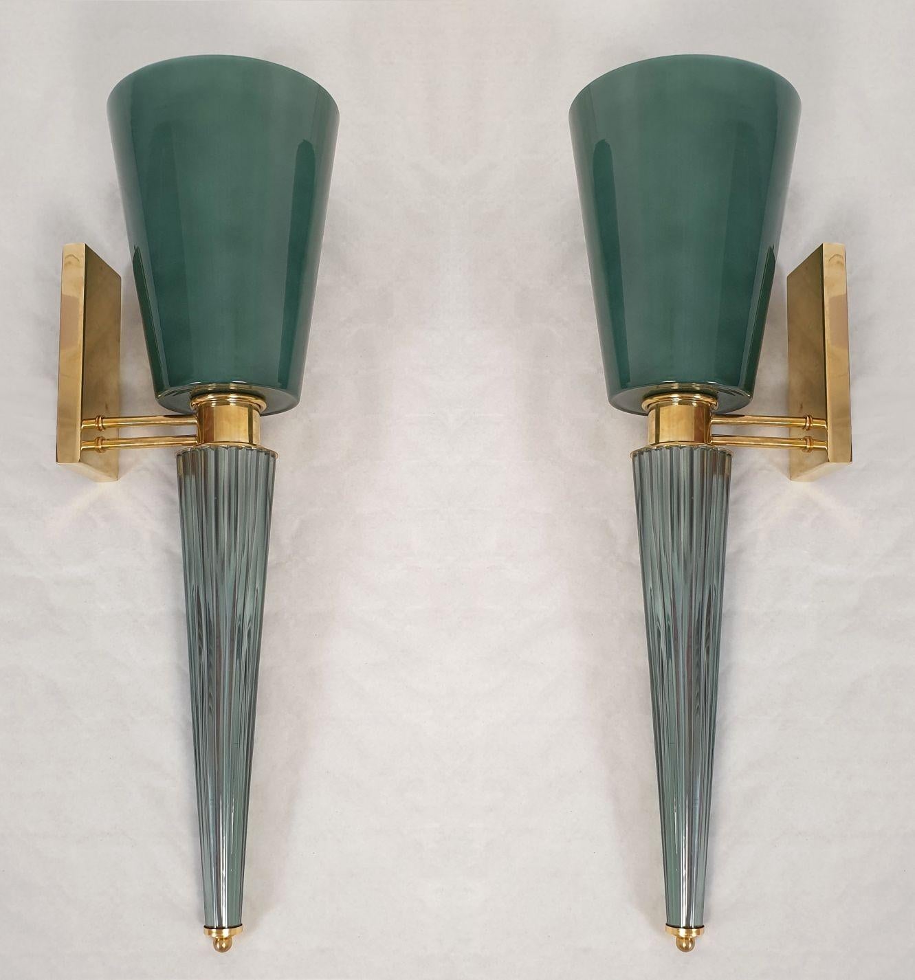 Pair of tall Murano glass and brass wall sconces, Attributed to Venini, Italy 1970s.
The Mid-Century Modern sconces are made of a top green Murano glass vase nesting the light bulb.
The glass is double layered: the inside is white. It's translucent,