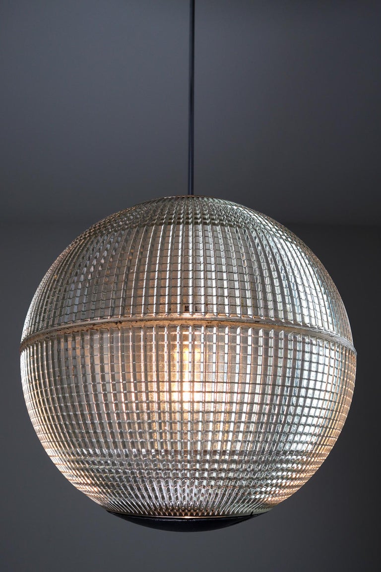 This is an large original late 1960s Paris globe Holophane street light from Paris, France now turned into a pendant light. The hallmark of Holophane luminaries, or lighting fixtures, is the borosilicate glass reflector / refactor. The glass prisms
