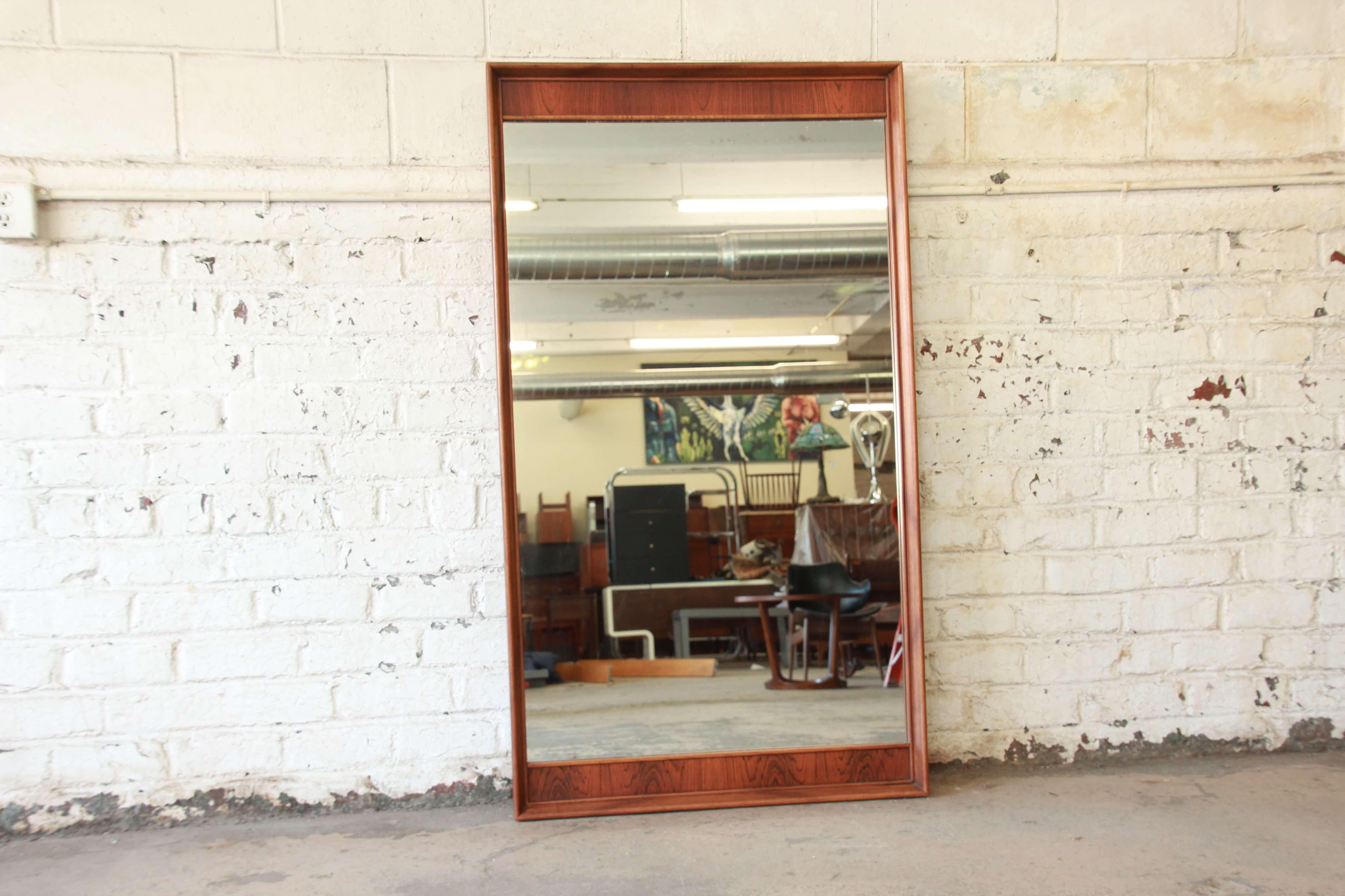 Offering a very nice walnut and rosewood Kent Coffey Perspecta wall mirror. The mirror has an ice solid walnut frame with rosewood details on the inside edge of the mirror. The mirror is in great vintage condition and would fit nicely in any