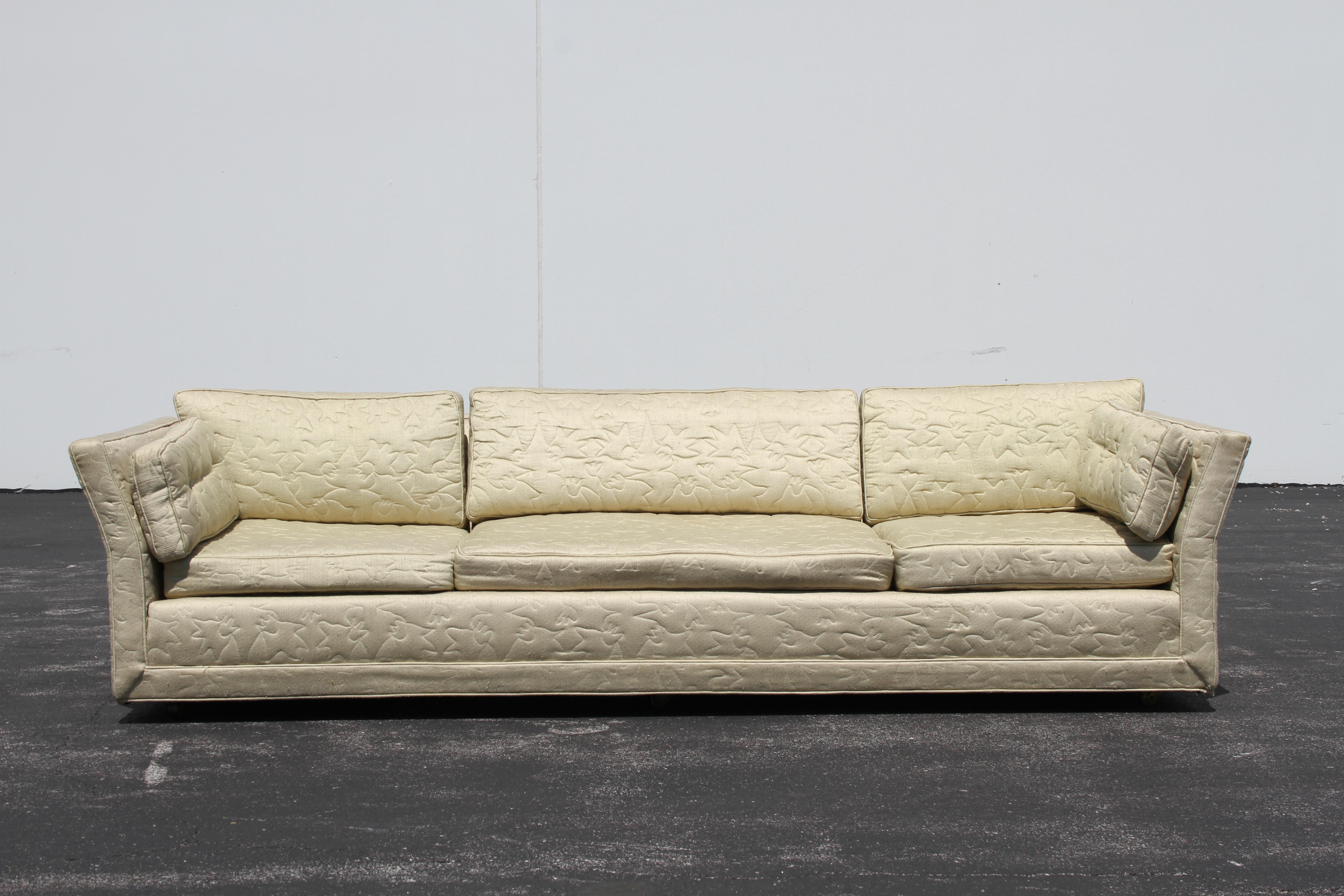 Originales Mid-Century Modern Sofa von Flair Inc. mit abgewinkelten Armlehnen auf Messingrollen, restaurierungsbedürftig. Dieses Sofa hat große Knochen, in der ursprünglichen gesteppten Polsterung, die Verschleiß und Flecken hat gezeigt. Strukturell