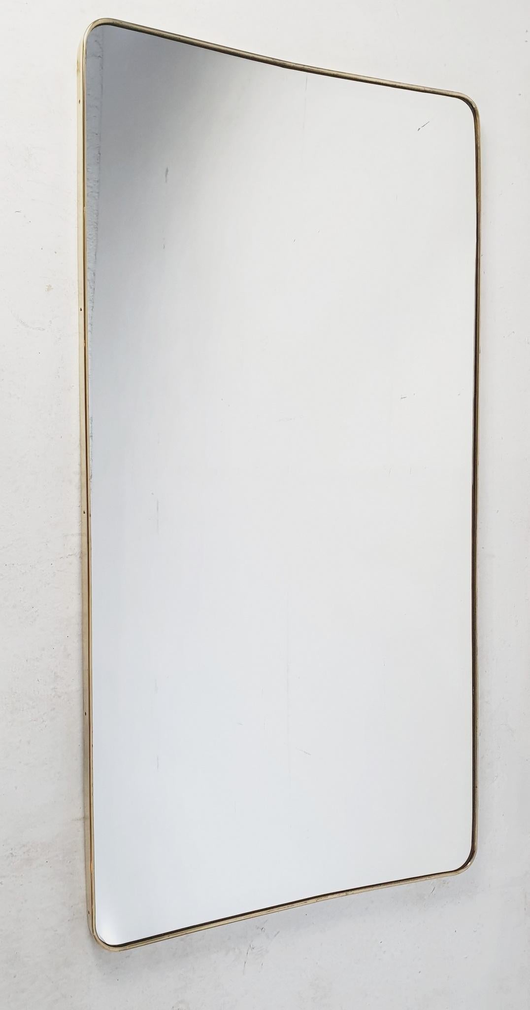 A full lenght wall mirror in the manner by Gio Ponti from the 1950's in brass with rounded corners and lightly beveled top and bottom. The glass is new and in perfect condition. Can be hung vertically or horizontally.