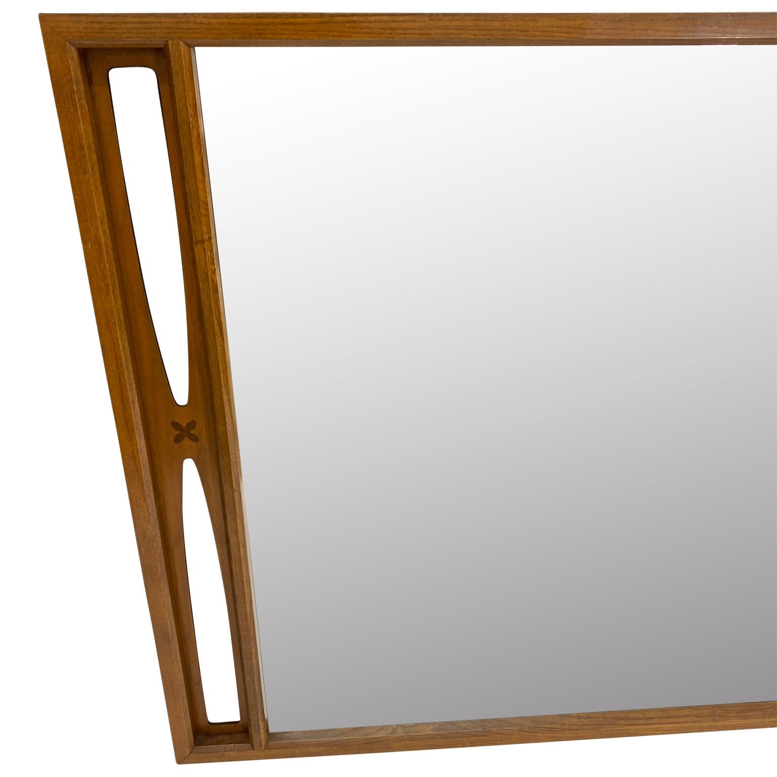 Mid-Century Modern mirror with inlay accents. This mirror is outstanding. The end pieces have inlay and cut-out design. The mirror can be hung on the diagonal or horizontal. A perfect example of Scandinavian style mid-century design, the mirror is