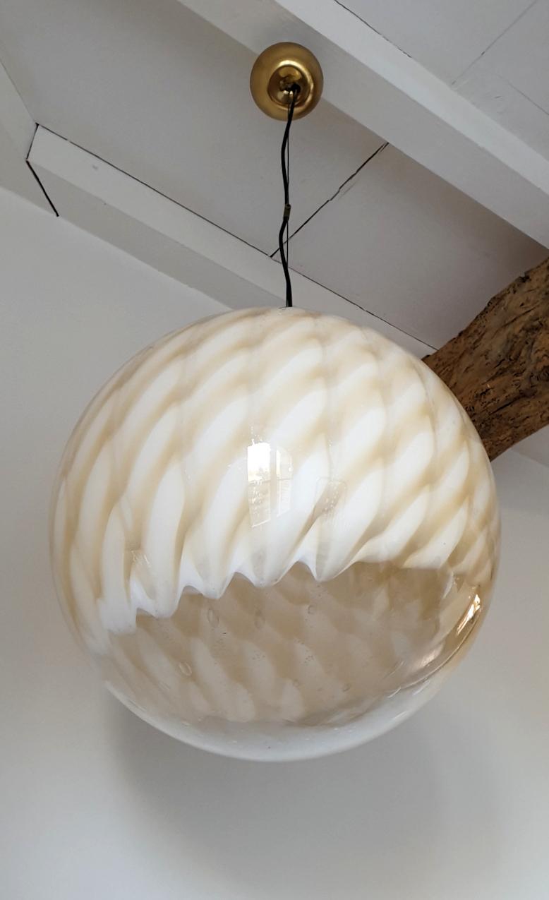 Large Mid-Century Modern stamped Murano glass pendant light, by Toni Zuccheri for Venini.
Italy, 1960s.
The large globe is made of white and beige Murano glass, with transparency in the bottom, and some air bubbles in the blown glass.
The vintage