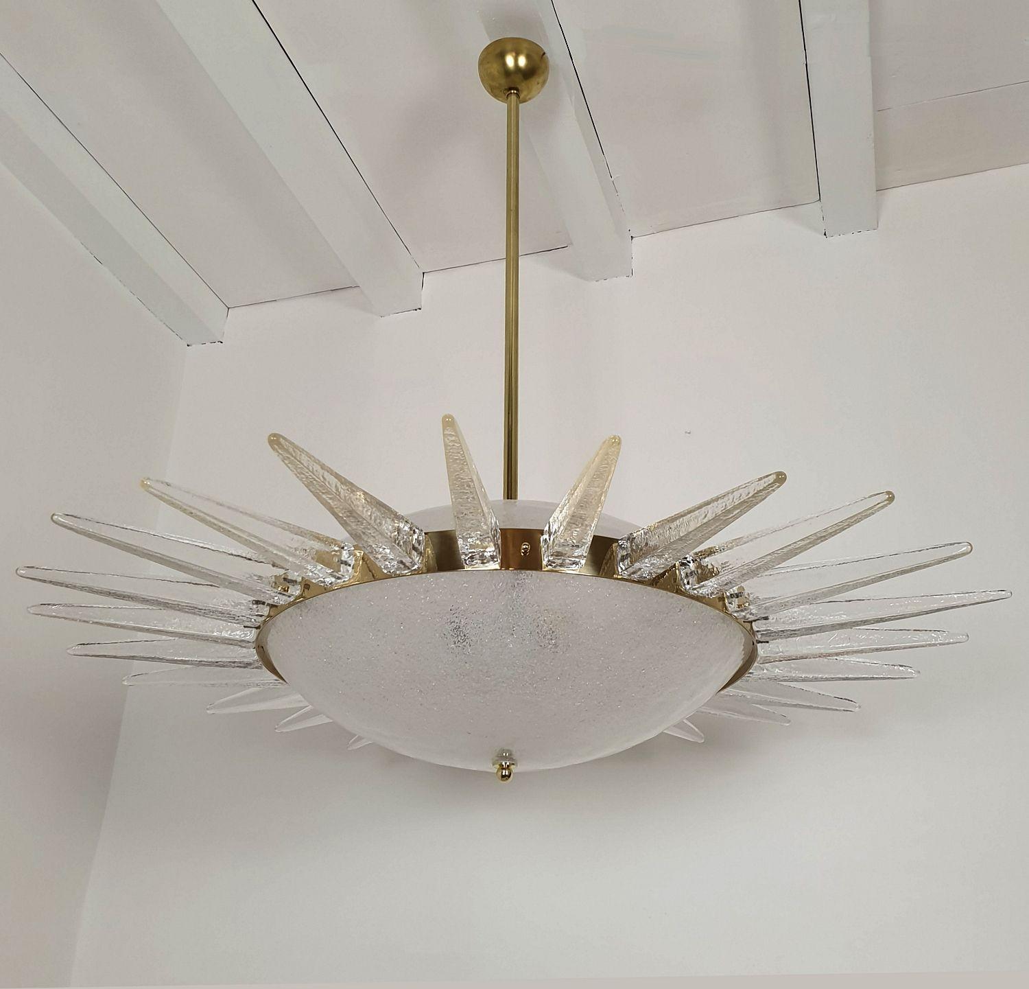 Mid Century Modern large Murano glass chandelier, attributed to Seguso, Italy 1970.
The chandelier is made of clear Murano glass: top and bottom central glasses are textured and translucent.
And it's surrounded with a Murano 