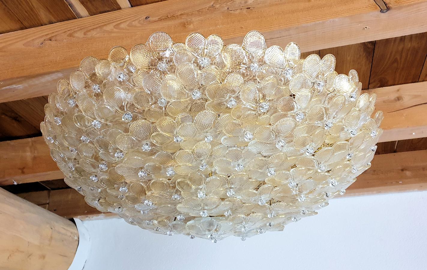 Large round Mid-Century Modern Murano glass flower chandelier, or flushmount ceiling light,
by Barovier & Toso, Italy, late 1970s.
The Murano glass flowers and clear with some gold flakes.
The frame is brass.
6-light, candelabra base sockets,
