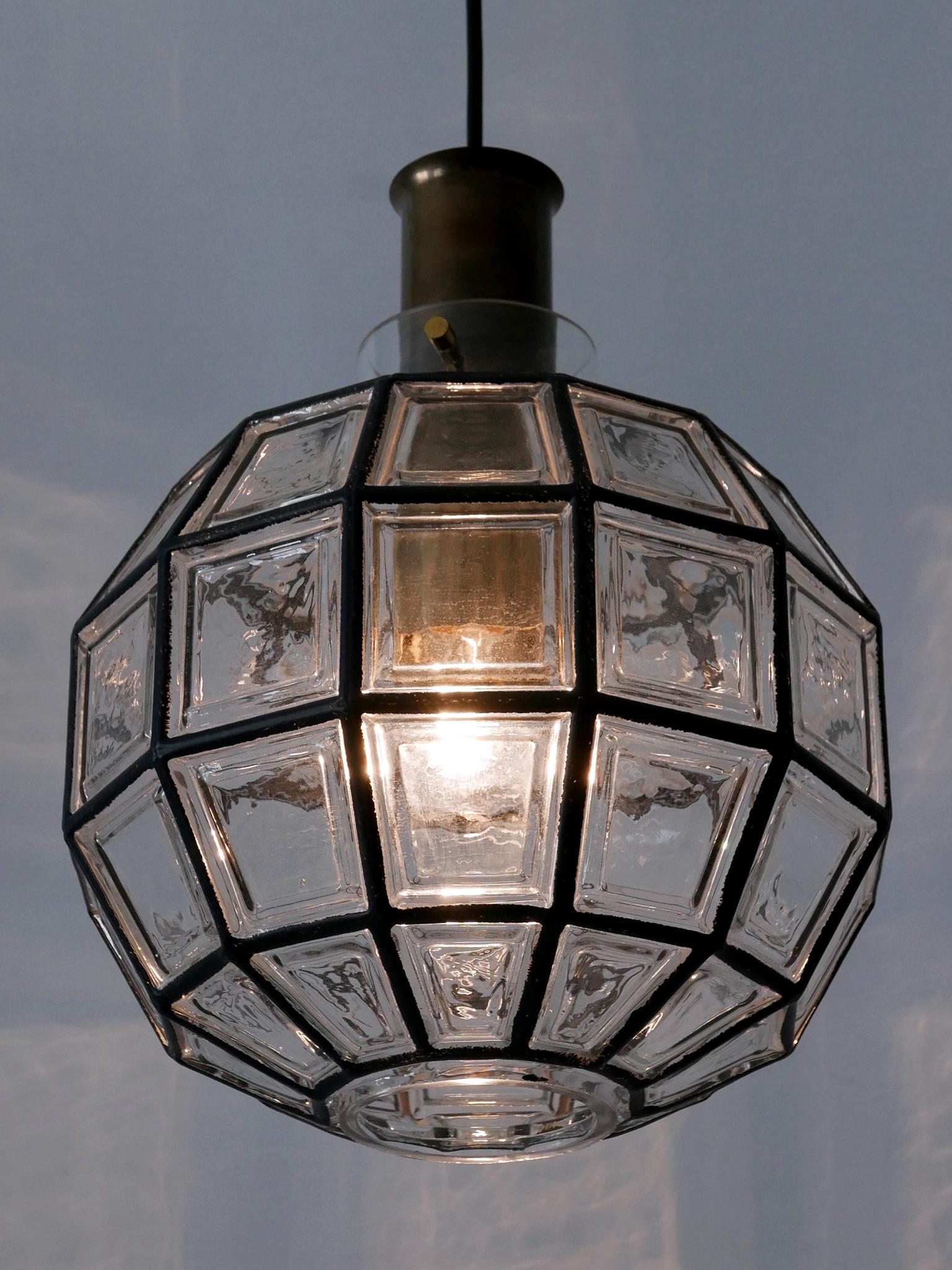 Lampada a sospensione o lampada a sospensione di stile Mid-Century Modern, elegante e altamente decorativa. Disegnato e prodotto da Glashütte Limburg, Germania, anni '60.

Realizzata in vetro e ottone, la lampada a sospensione è dotata di 1