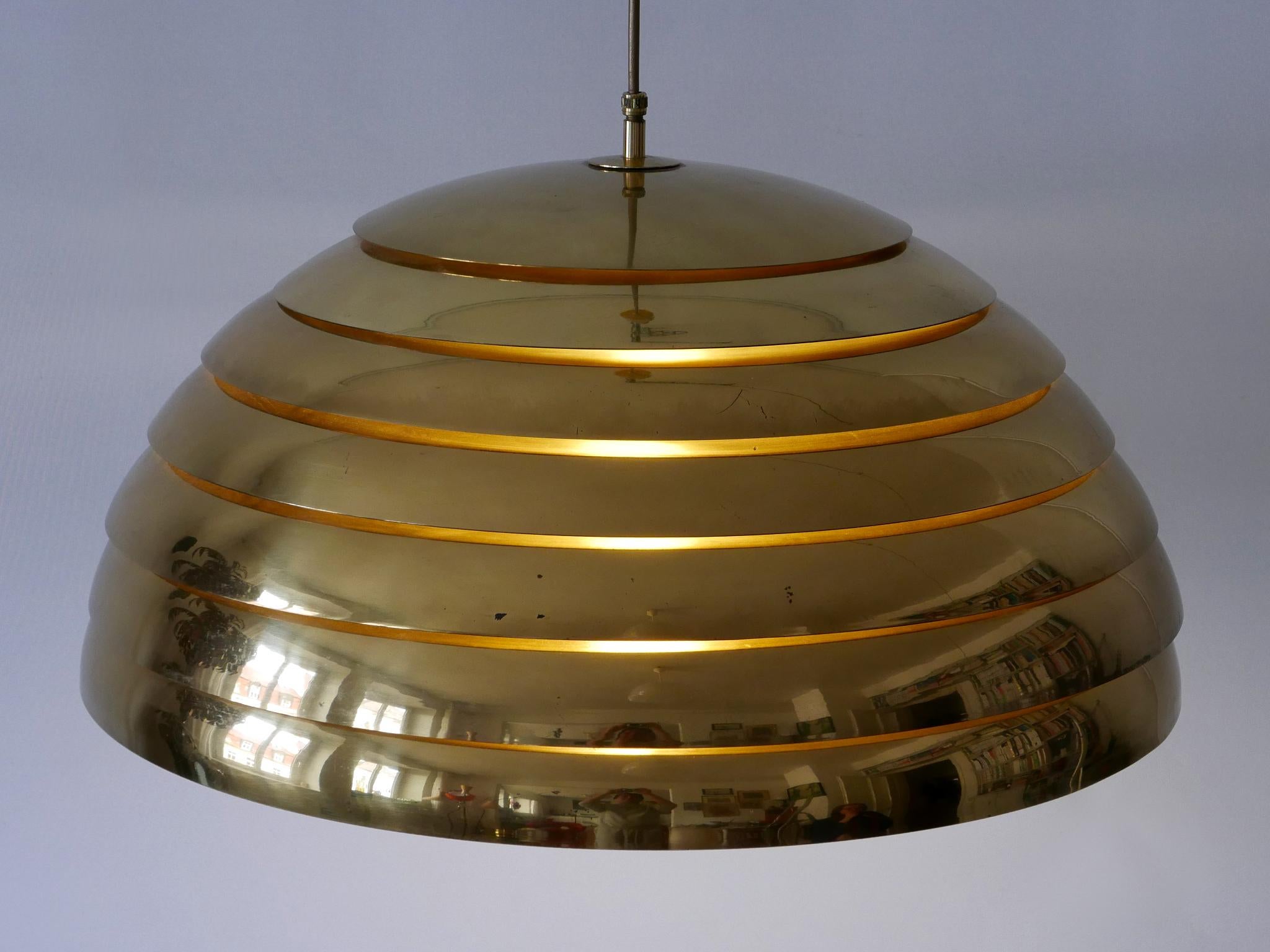 Large and elegant Mid-Century Modern brass pendant lamp or hanging light. Suits perfect for a dining table. Designed and manufactured by Vereinigte Werkstätten München, Germany, 1960s.

Executed in brass and semi-opaque lucite, the pendant lamp