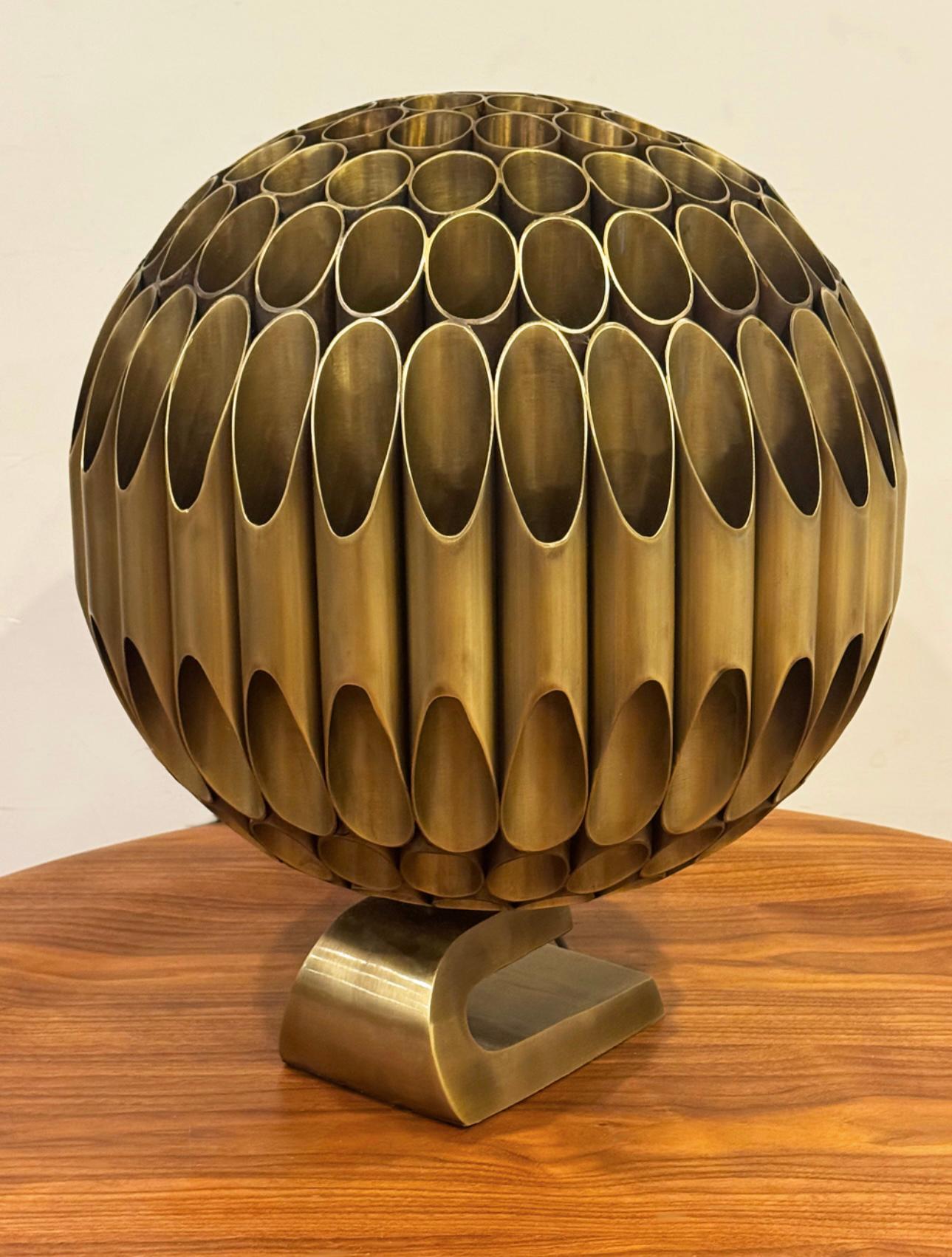 Grande e imponente lampada scultorea a sfera in ottone di Michel Armand. Presenta tubi e base in ottone saldati. Perfettamente funzionante e in buone condizioni, presenta un'usura dell'ottone dovuta all'età. 