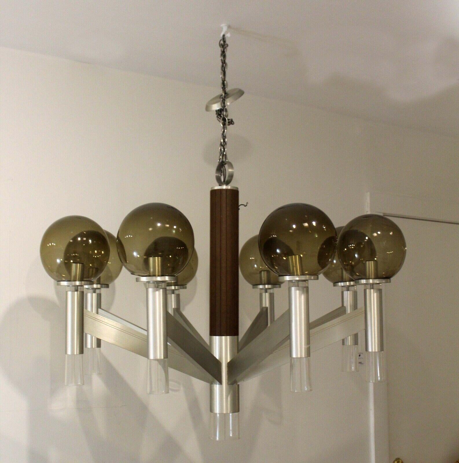 Frome Le Shoppe Too in Michigan comes this stunning mid century modern chandelier reminiscent of Robert Sonneman's famous lollipop globe lighting from the 1970's. This fixture has 8 walnut candles, each topped with their own round smoked glass globe