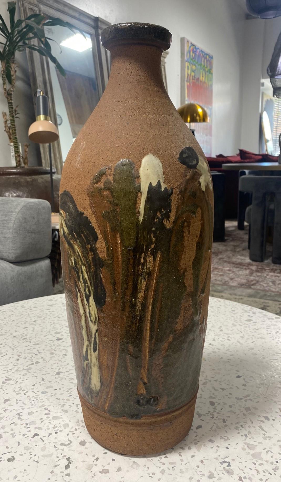 A wonderful, richly multi-glazed and textured, heavy Mid-Century Modern large stoneware bottle vase. Expertly crafted. The piece is very reminiscent of some of Peter Voulkos' early hand-painted works with traditional shaped vessels, though we