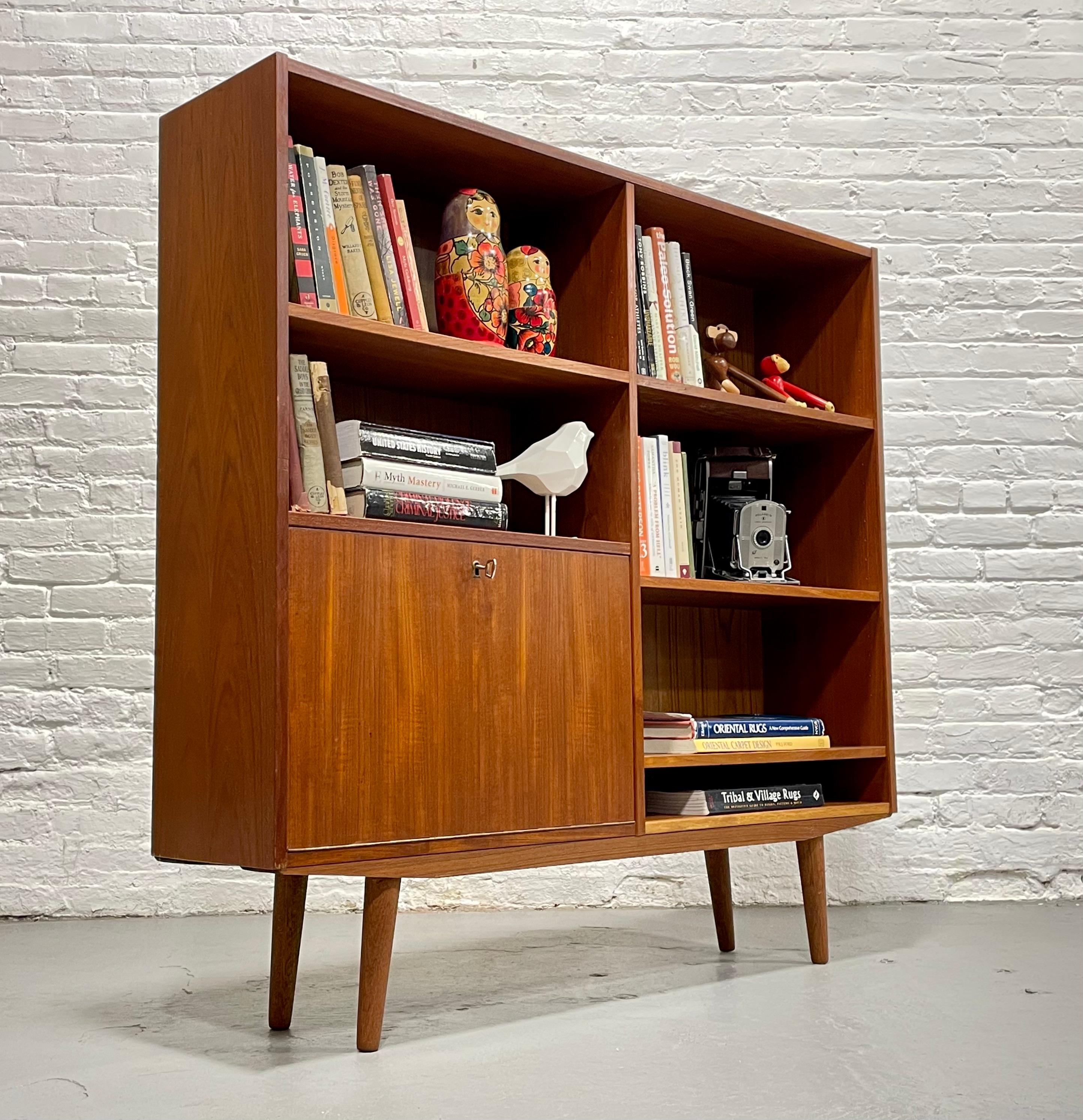 Mid Century Modern Teak Bookcase / Bar, Made in Denmark, c. 1960’s.  This beauty offer loads of storage for all your books and collectables or use it as an amazing liquor or china cabinet.  Tons of gorgeous design details such as a drop down