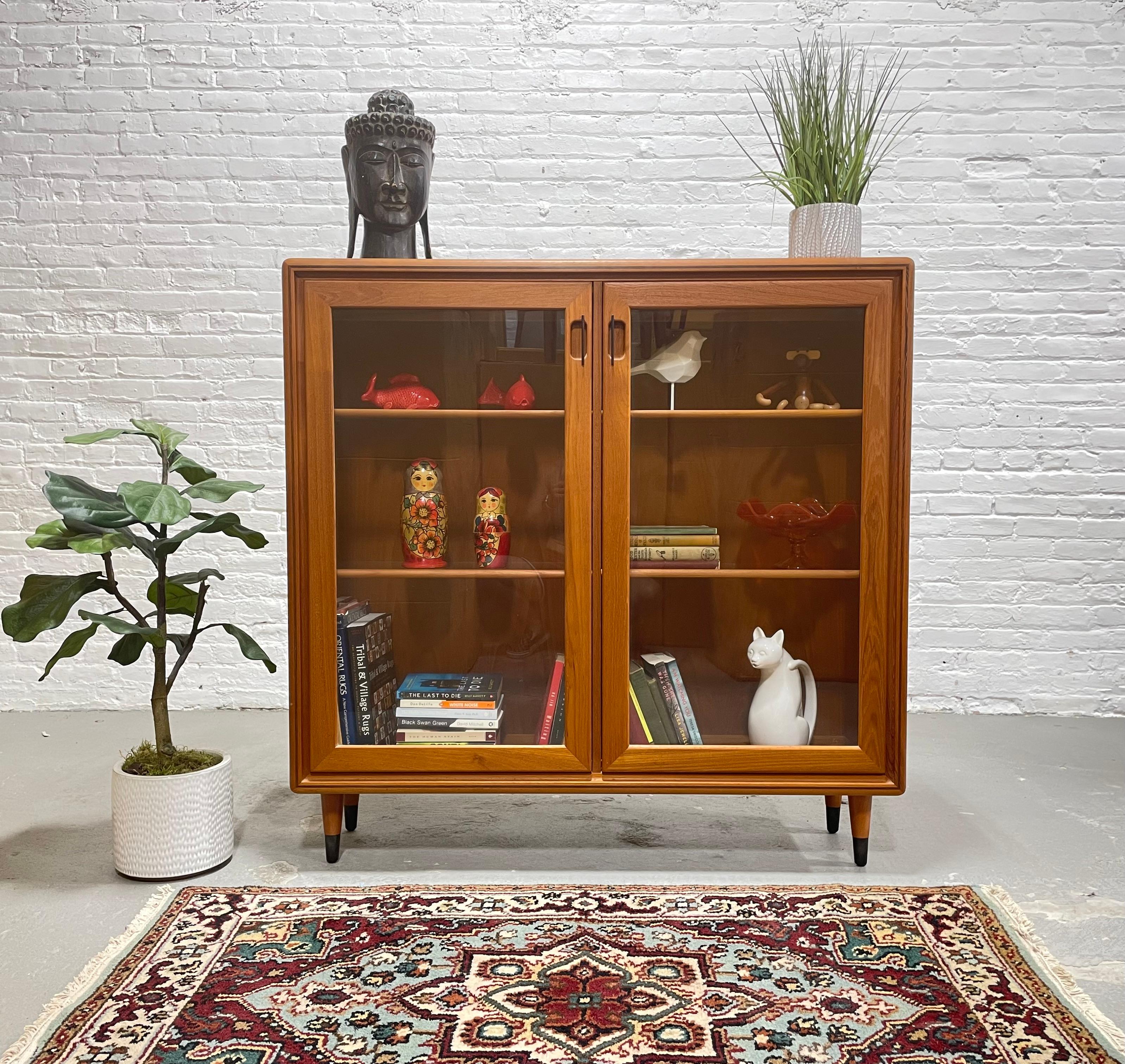 Mid Century Modern Teak Bookcase, Made in Denmark, c. 1960’s.  Not only does this beauty offer loads of storage for all your books and collectables, but it also lights up and would make an amazing bar cabinet.  Tons of gorgeous design details: glass