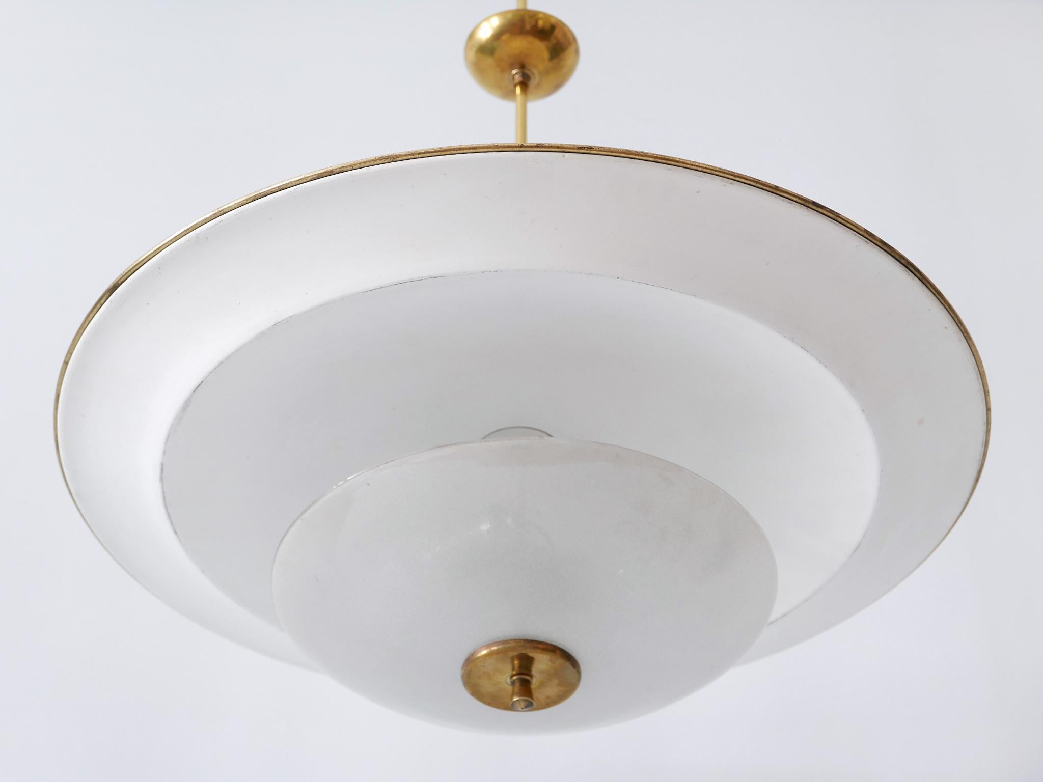 Large, rare and highly decorative Mid-Century Modern 'Ufo' ceiling light or pendant lamp. Designed & manufactured in Germany, 1950s.

Executed in aluminum sheet, textured glass and brass, the pendant lamp needs 2 x E27 / E26 Edison screw fit bulbs.