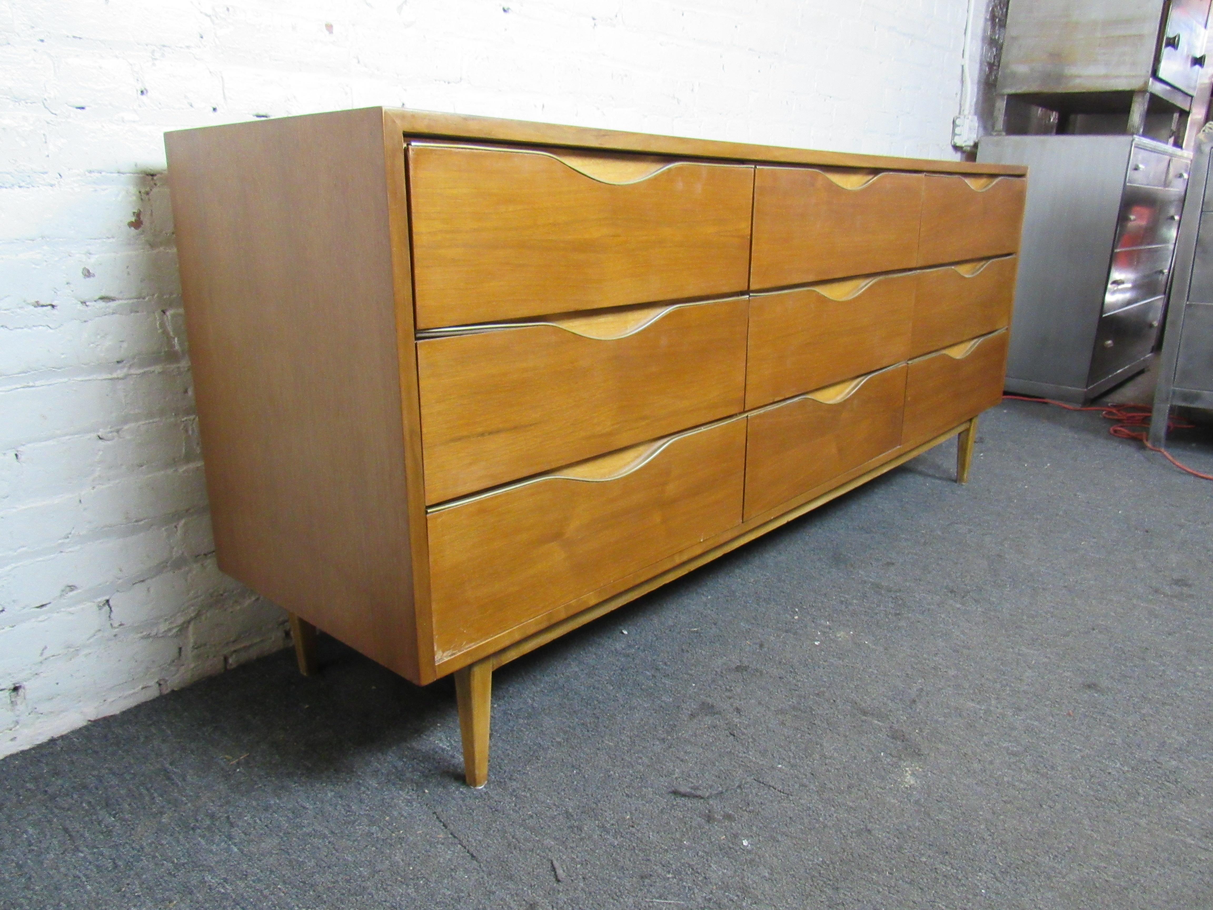 Stunning walnut woodgrain is paired with solid mid-century craftsmanship in this large vintage dresser. Nine drawers provide plenty of space for storage in a beautiful and timeless design. Please confirm item location with seller (NY/NJ).