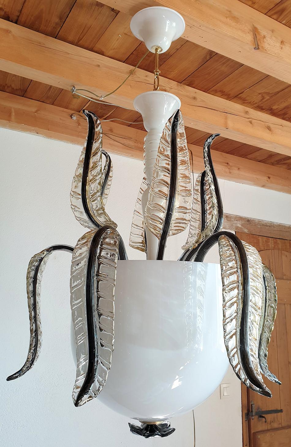 Vintage Murano glass large lantern or chandelier, attributed to Seguso, Italy, 1970s.
The large Mid-Century Modern Murano chandelier is made of a delicate white translucent glass bowl, nesting the lights; clear and gold handmade leaves, with black