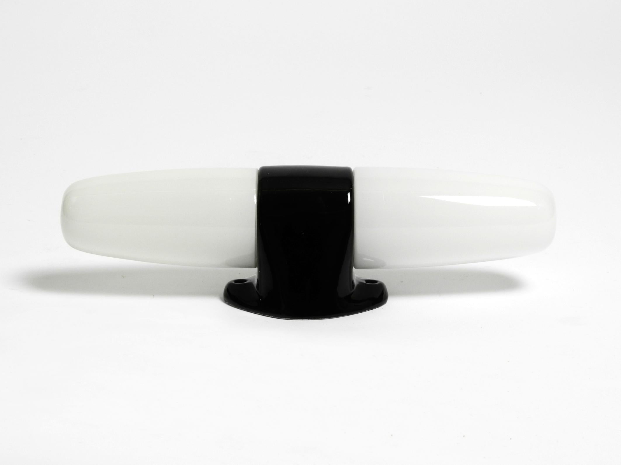 Rare grande lampe murale en céramique à double verre de style moderne du milieu du siècle dernier.
Design/One : Wilhelm Wagenfeld. Fabriqué en Allemagne.
Design minimaliste en verre lourd. Socle et prises en céramique laquée noire.
Convient comme