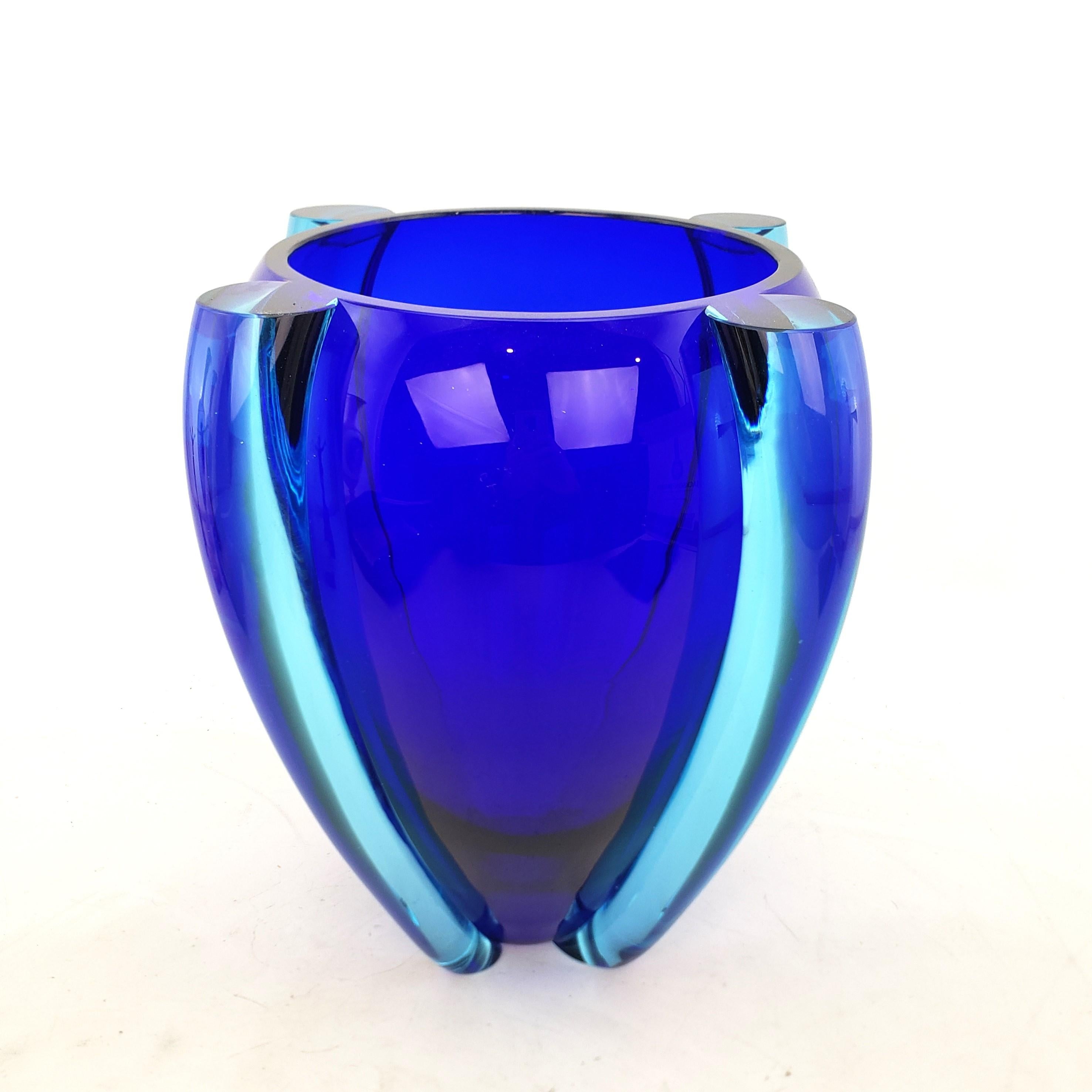 This large art glass vase is signed by an unknown artist,  and presumed to have originated from Italy and date to 1989 and done in a Mid Century Modern style. The vase is composed of a large cobalt blue  center with thick turquoise or acqua blue