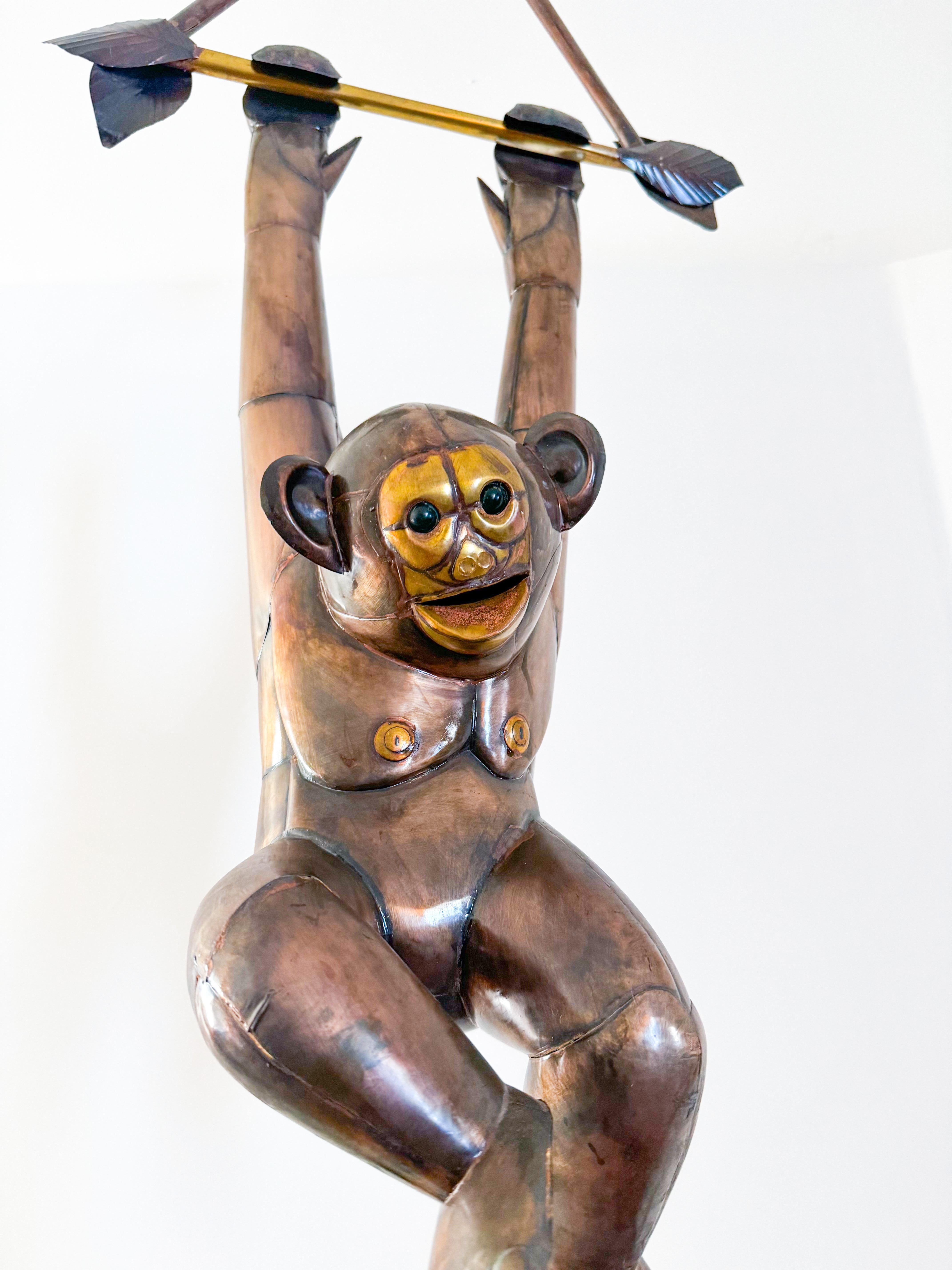 A rare and captivating Mid Century brass and copper hanging monkey sculpture in the style of renowned Mexican artist Sergio Bustamante, crafted in the 1970s. This large-scale sculpture showcases exceptional craftsmanship, featuring a monkey in a