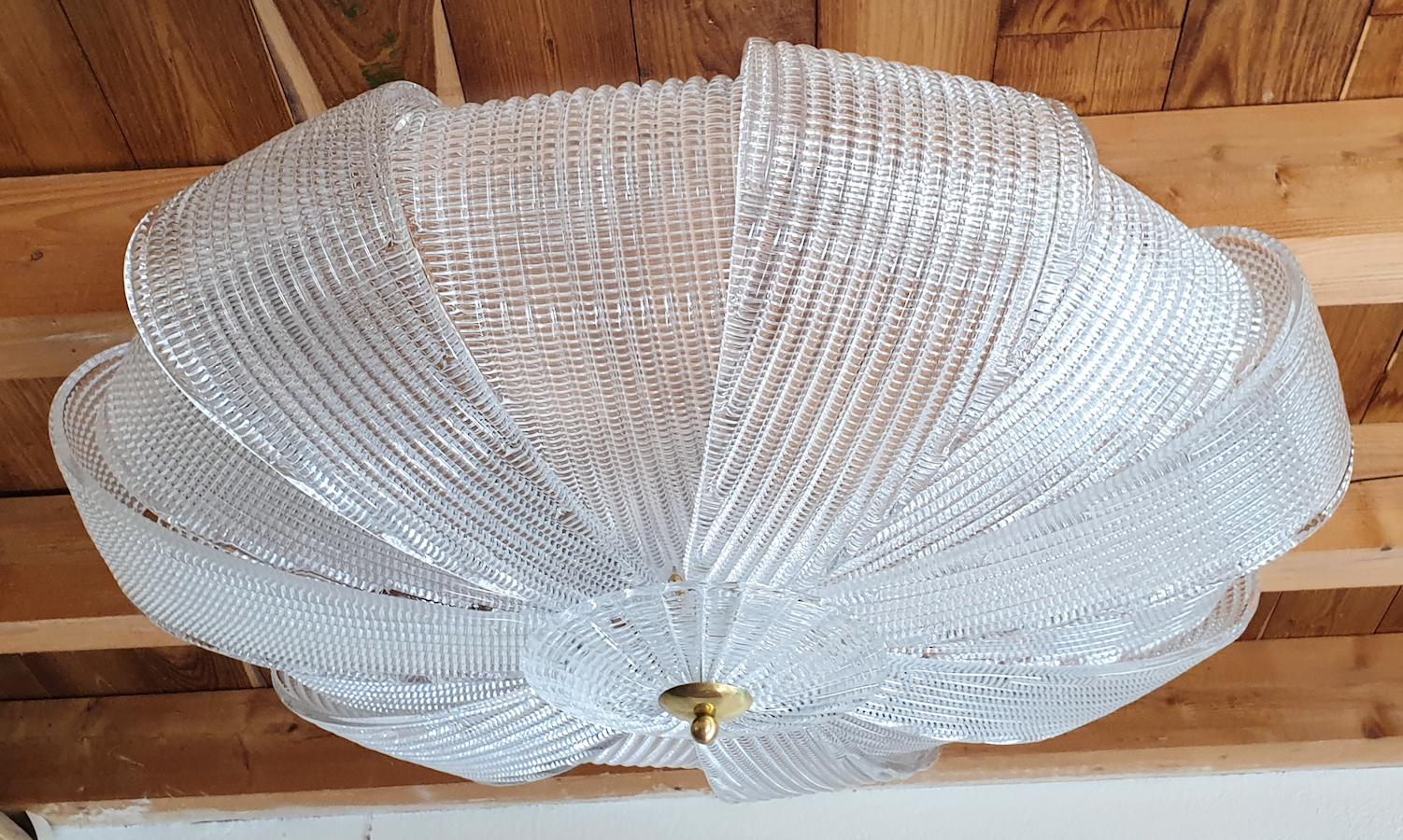 Large round Mid-Century Modern Murano clear textured glass flush mount ceiling lights, Barovier and Toso style, Italy circa 1970s.
The large vintage chandelier has white painted mounts. has been cleaned.
The Murano flush mount has 8 lights, and is