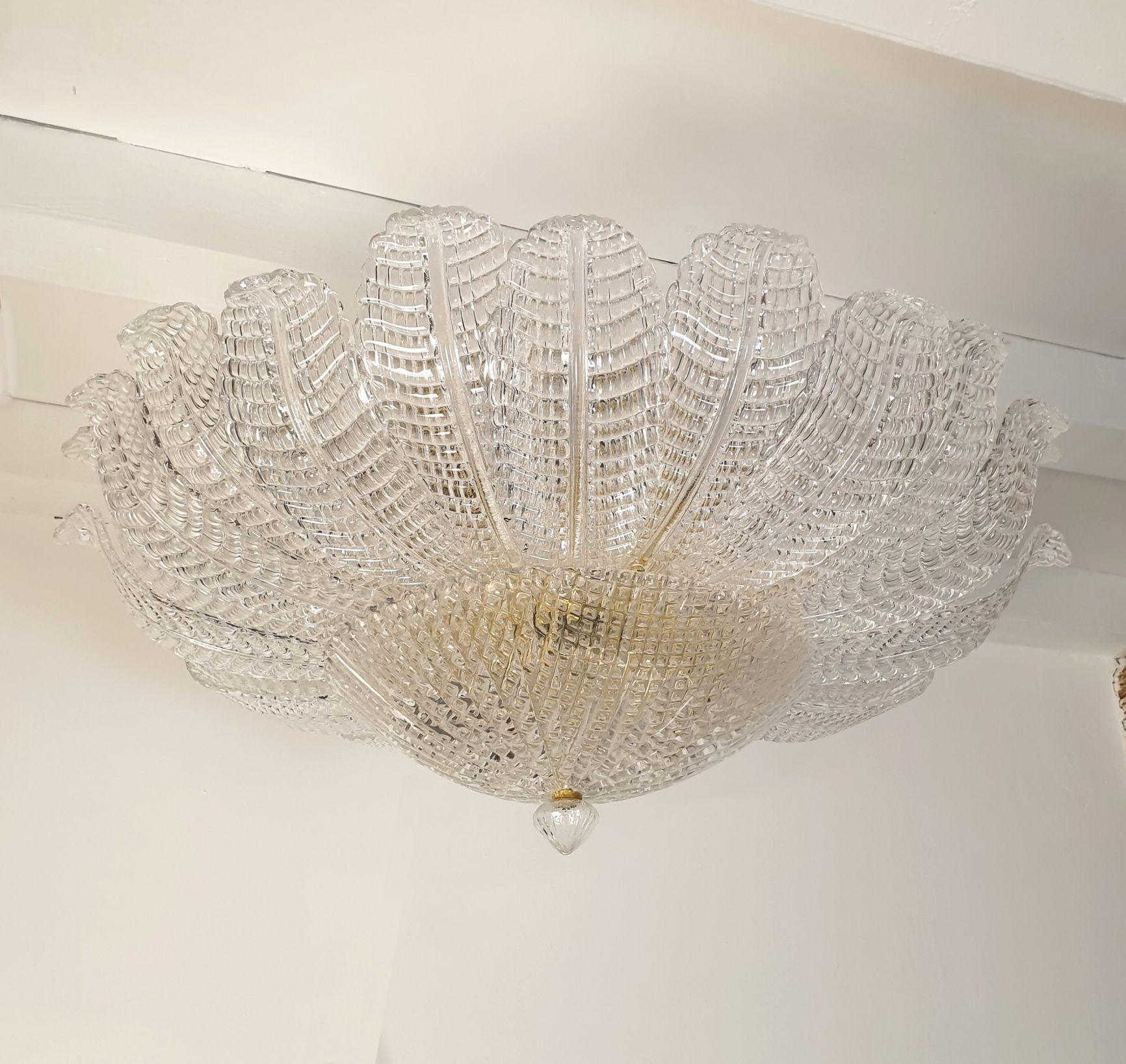 Large Mid-Century Modern Murano glass leaves chandelier, Barovier style, Italy 1970s.
The large chandelier is made of clear Murano glass leaves, with a grid pattern, making them translucent through the light.
This pattern is typical from the